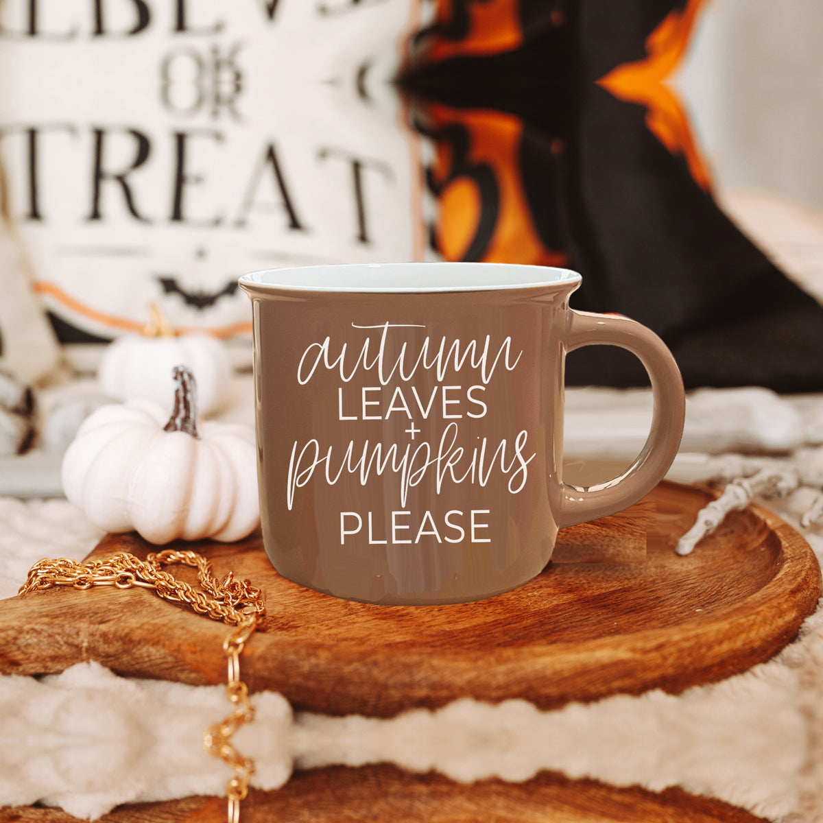 A ceramic campfire style mug featuring a neutral brown tone with white lettering that reads 'Autumn Leaves + Pumpkins Please', designed for fall.