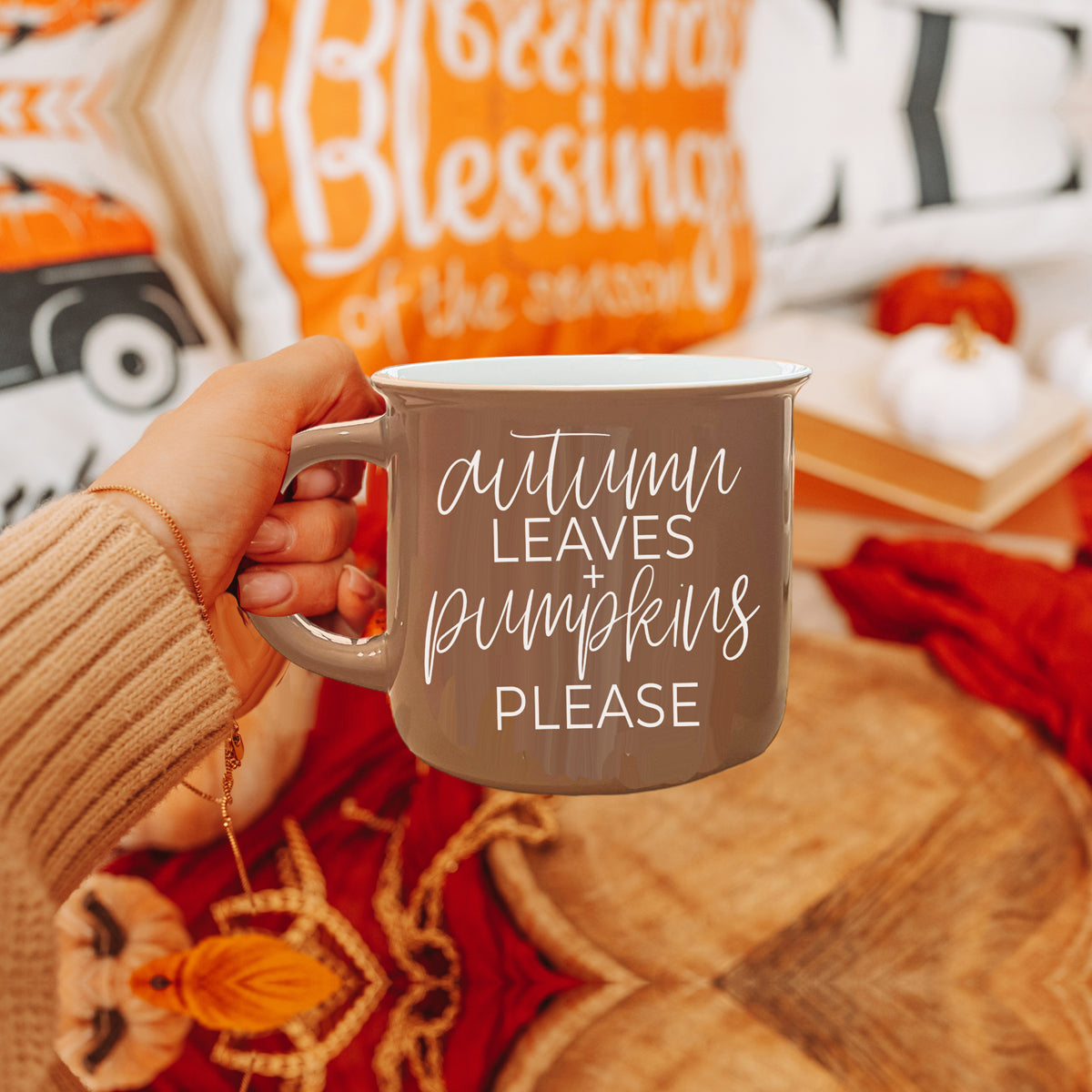 A ceramic campfire style mug featuring a neutral brown tone with white lettering that reads 'Autumn Leaves + Pumpkins Please', designed for fall.