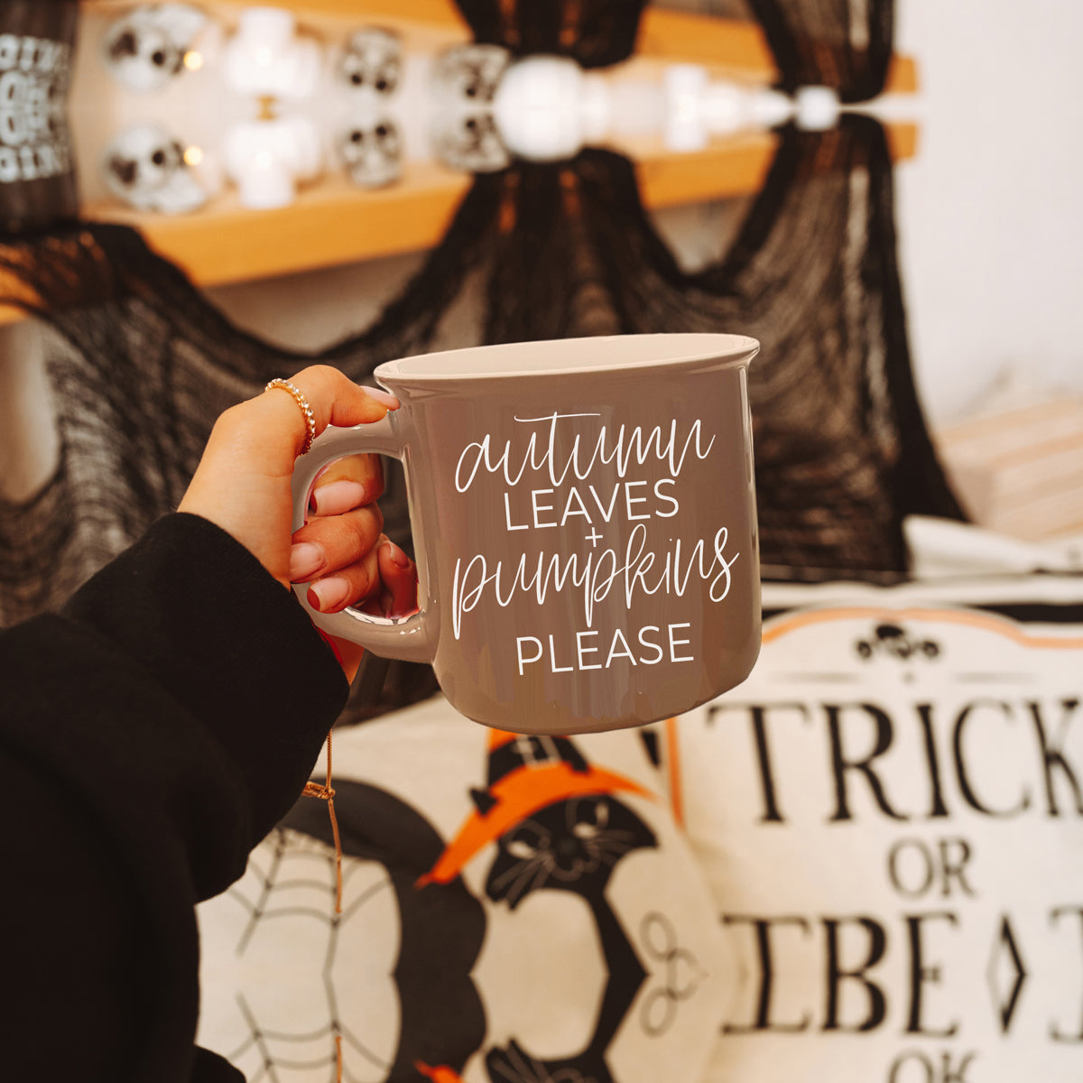 A ceramic campfire style mug featuring a neutral brown tone with white lettering that reads 'Autumn Leaves + Pumpkins Please', designed for fall.