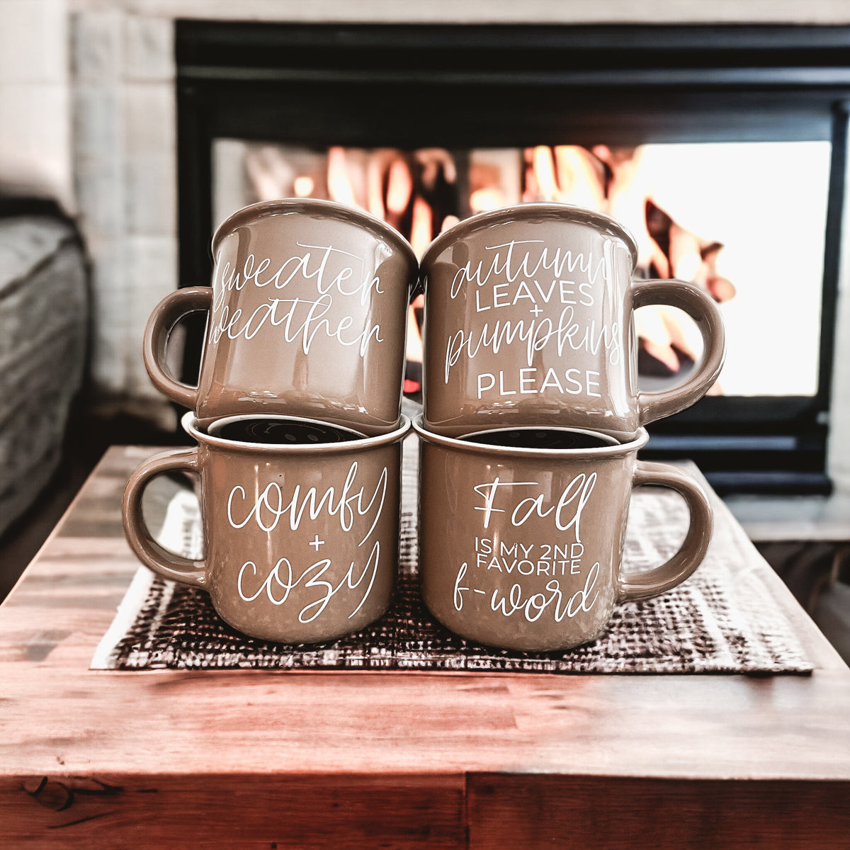 A ceramic campfire style mug featuring a neutral brown tone with white lettering that reads 'Autumn Leaves + Pumpkins Please', designed for fall.