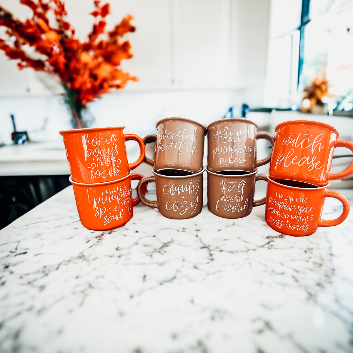 A ceramic campfire style mug featuring a neutral brown tone with white lettering that reads 'Autumn Leaves + Pumpkins Please', designed for fall.