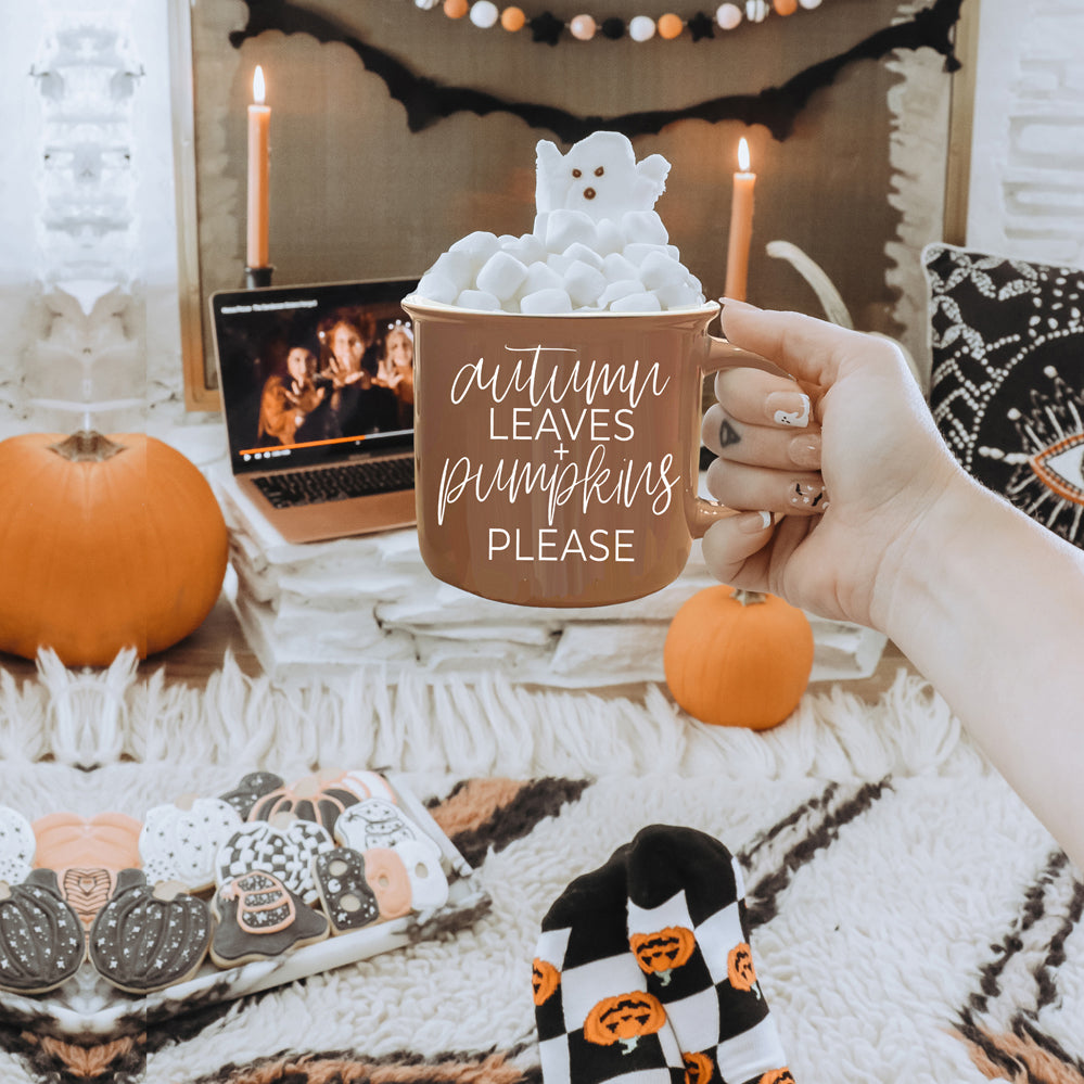 A ceramic campfire style mug featuring a neutral brown tone with white lettering that reads 'Autumn Leaves + Pumpkins Please', designed for fall.