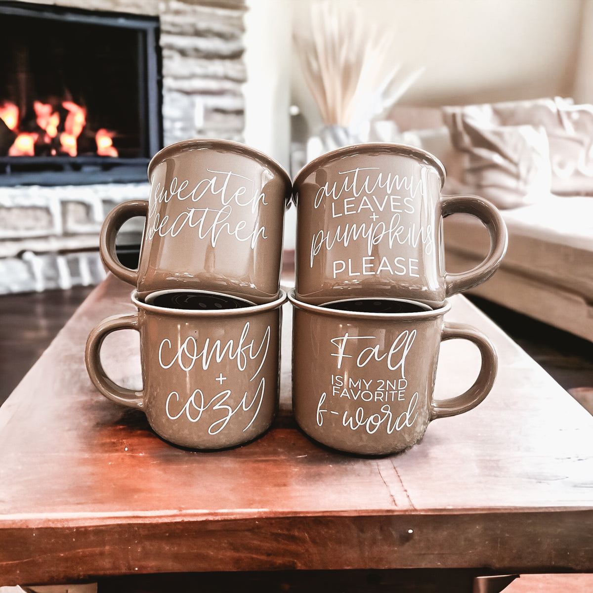 A ceramic campfire style mug featuring a neutral brown tone with white lettering that reads 'Autumn Leaves + Pumpkins Please', designed for fall.