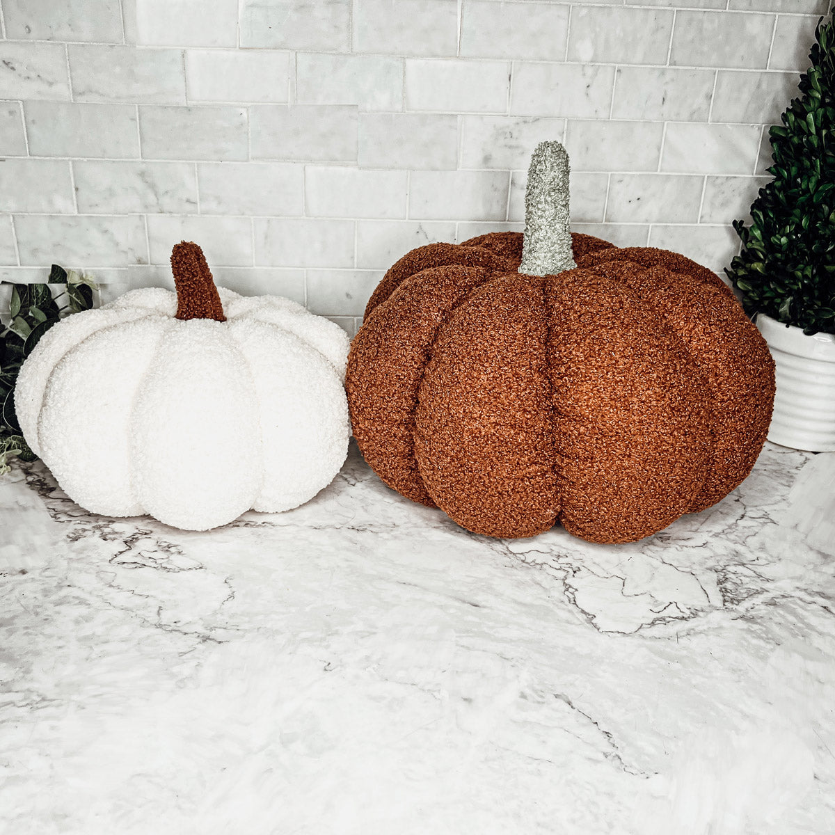 A collection of plush Blair Pumpkins in various colors including blue, gray, and orange, showcasing their soft texture and classic pumpkin shape.