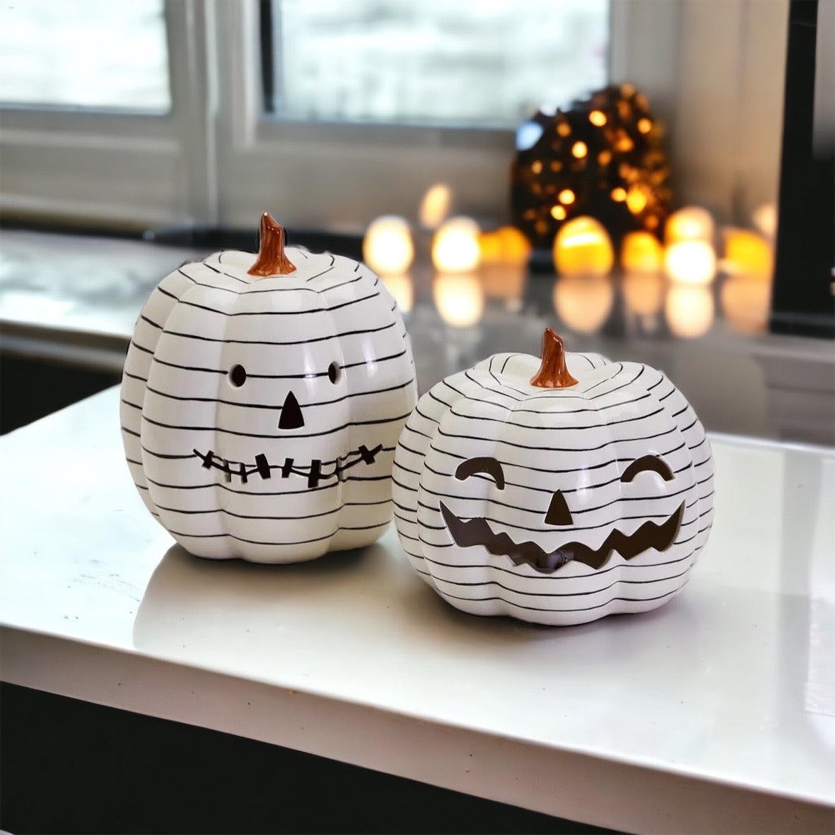 A hand-painted black and white LED pumpkin with a contemporary striped design, perfect for Halloween decor.