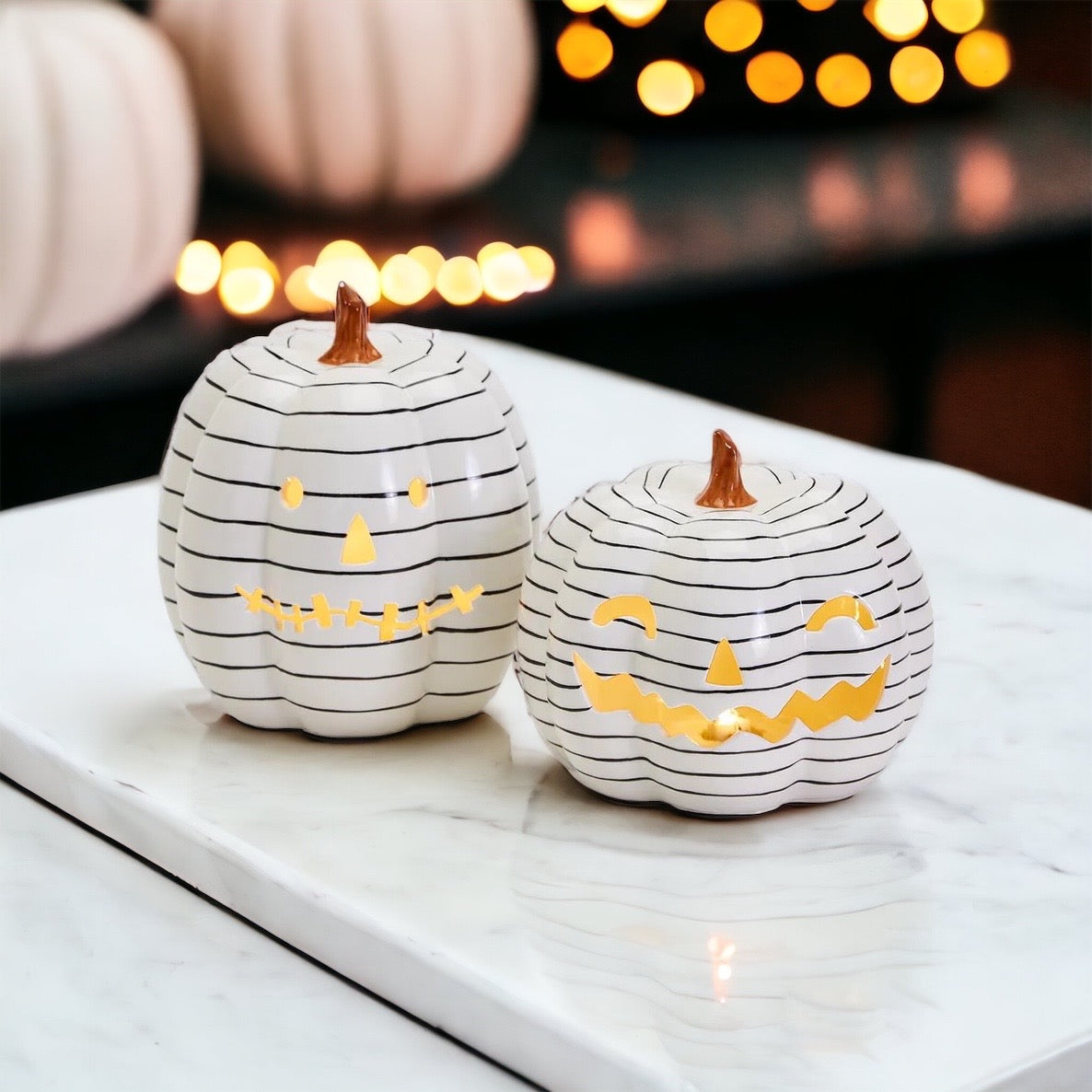 A hand-painted black and white LED pumpkin with a contemporary striped design, perfect for Halloween decor.