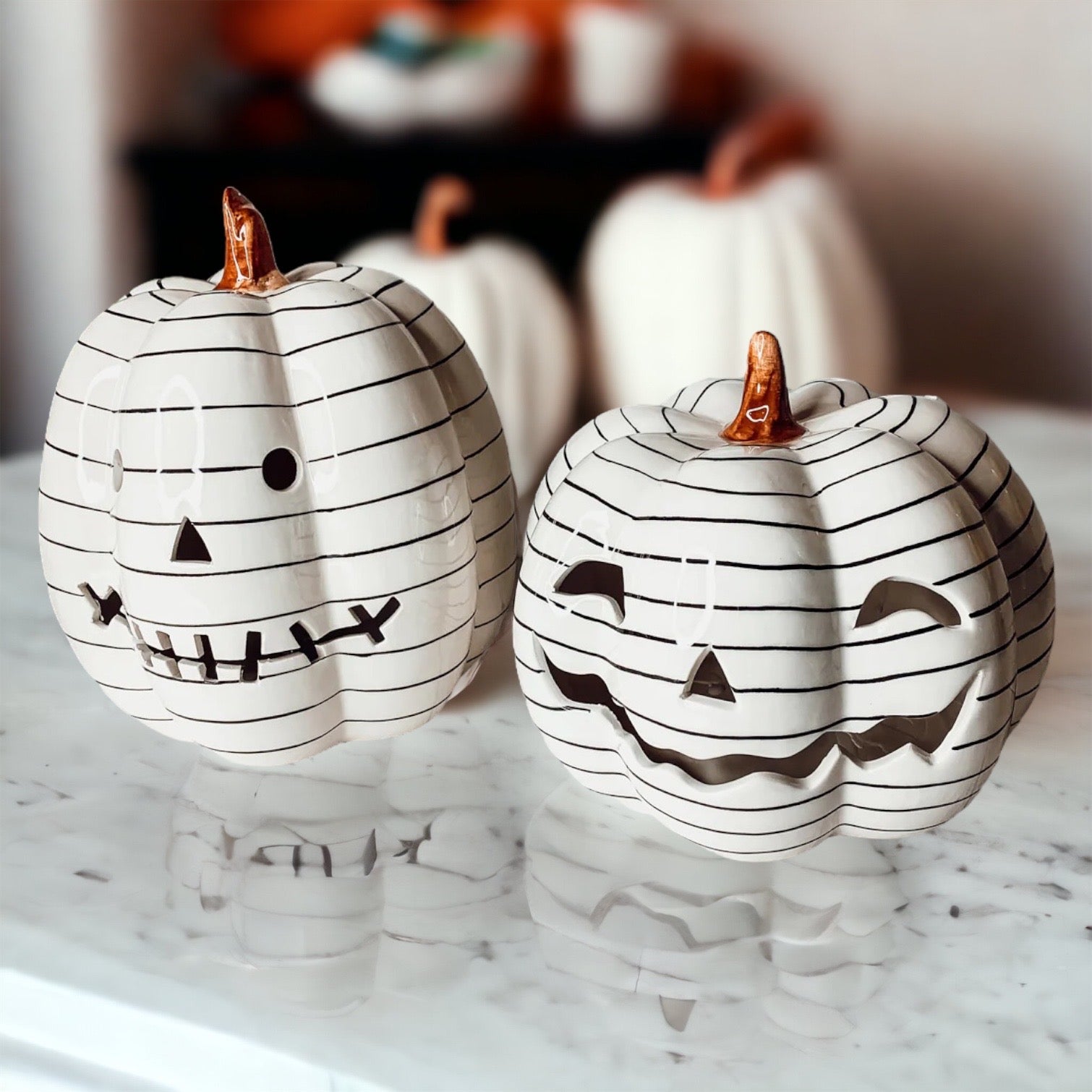 A hand-painted black and white LED pumpkin with a contemporary striped design, perfect for Halloween decor.