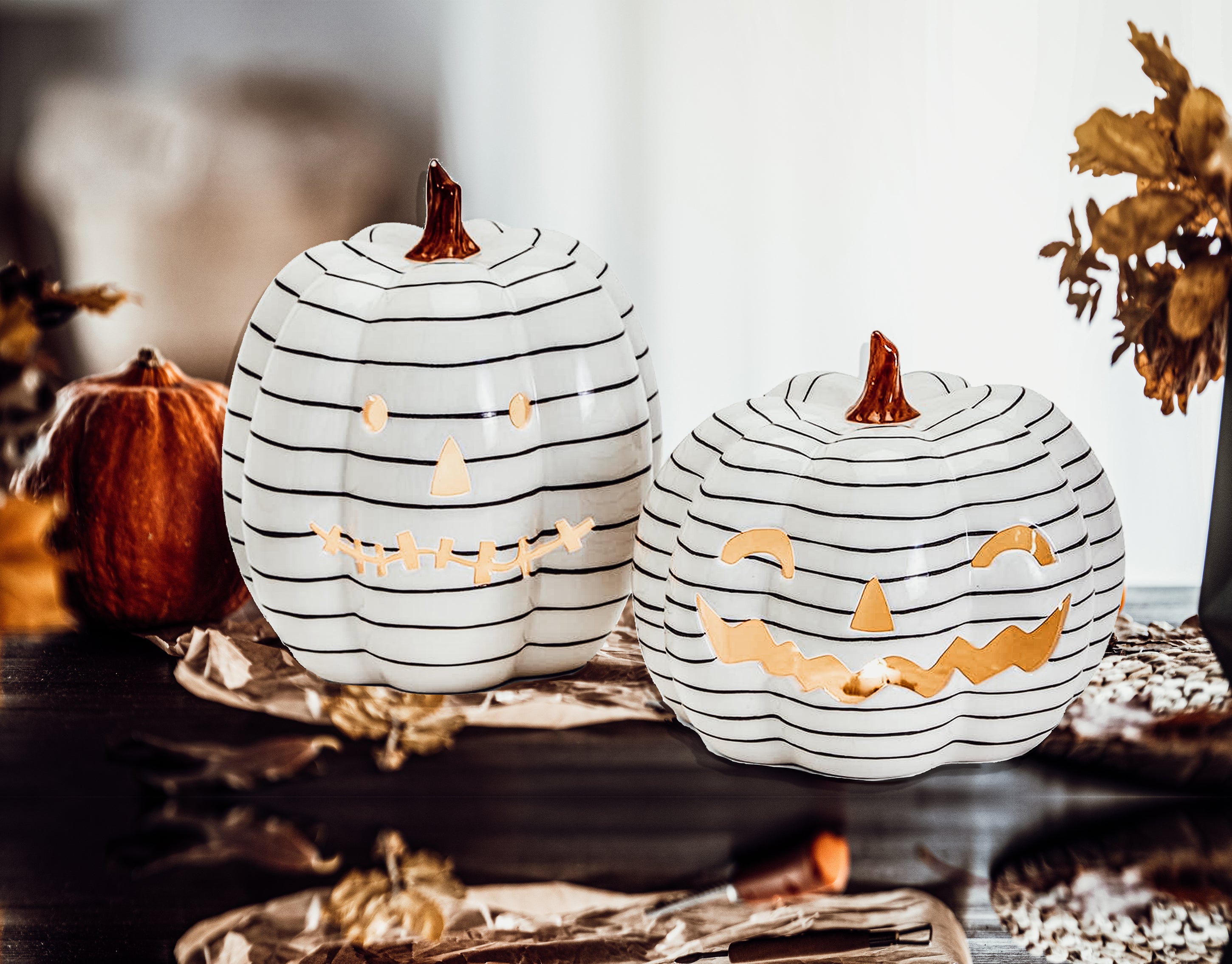 A hand-painted black and white LED pumpkin with a contemporary striped design, perfect for Halloween decor.