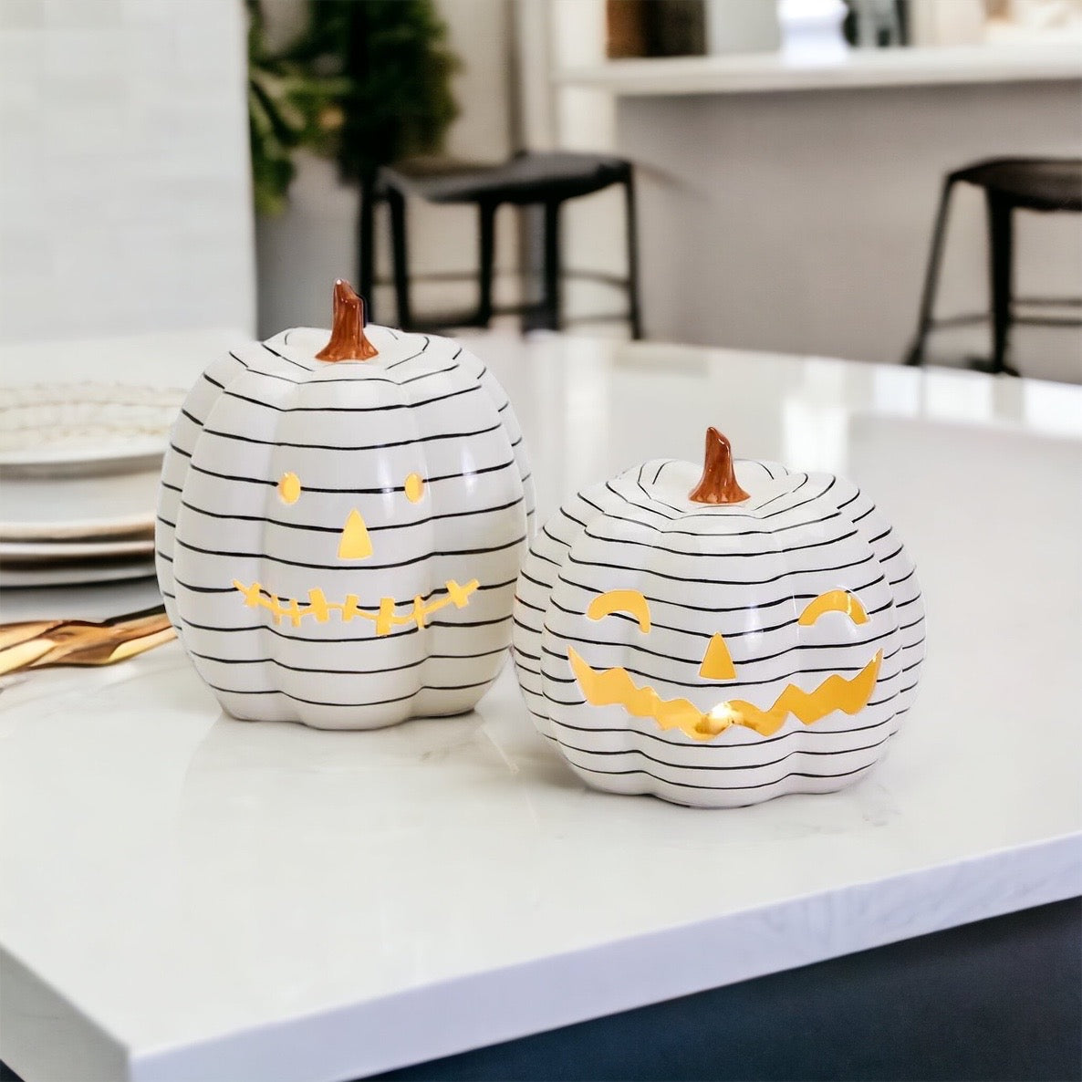 A hand-painted black and white LED pumpkin with a contemporary striped design, perfect for Halloween decor.