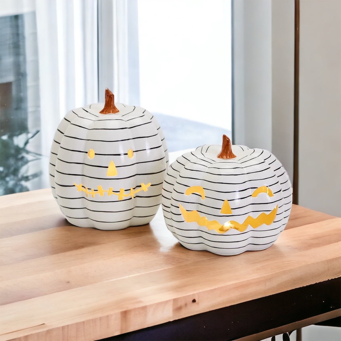 A hand-painted black and white LED pumpkin with a contemporary striped design, perfect for Halloween decor.