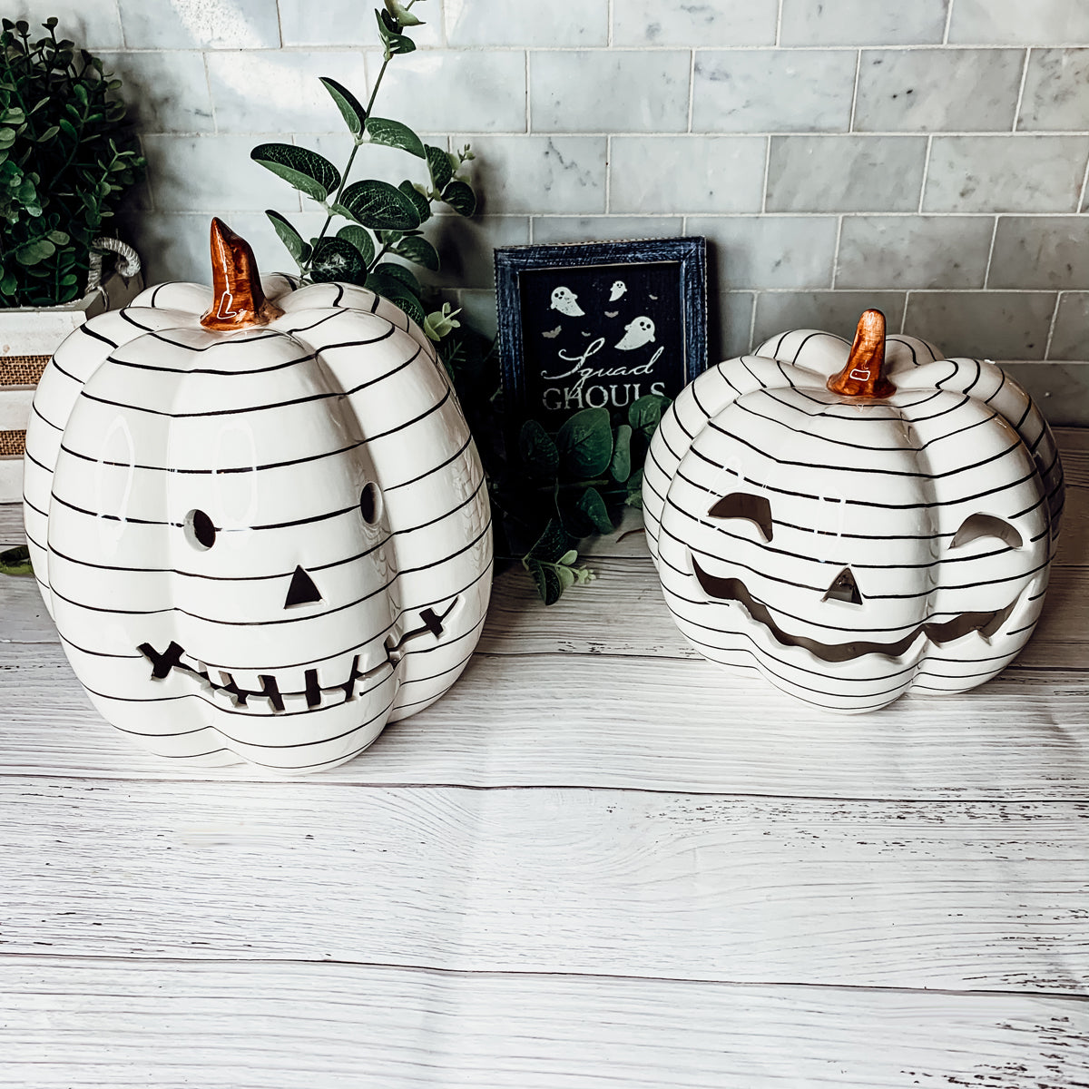 A hand-painted black and white LED pumpkin with a contemporary striped design, perfect for Halloween decor.