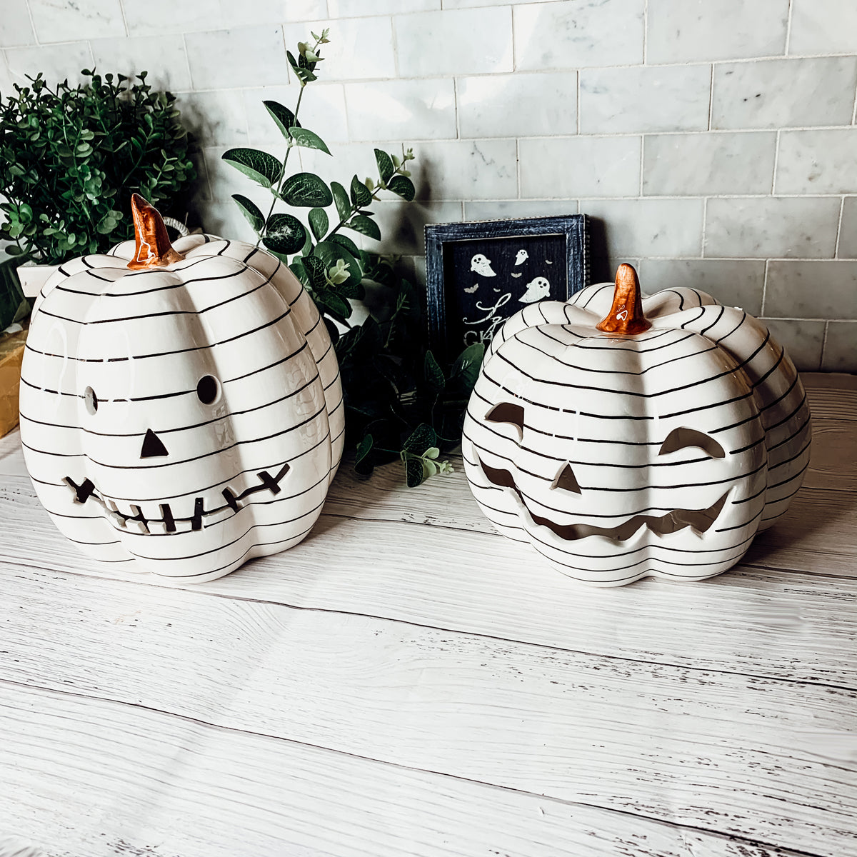 A hand-painted black and white LED pumpkin with a contemporary striped design, perfect for Halloween decor.