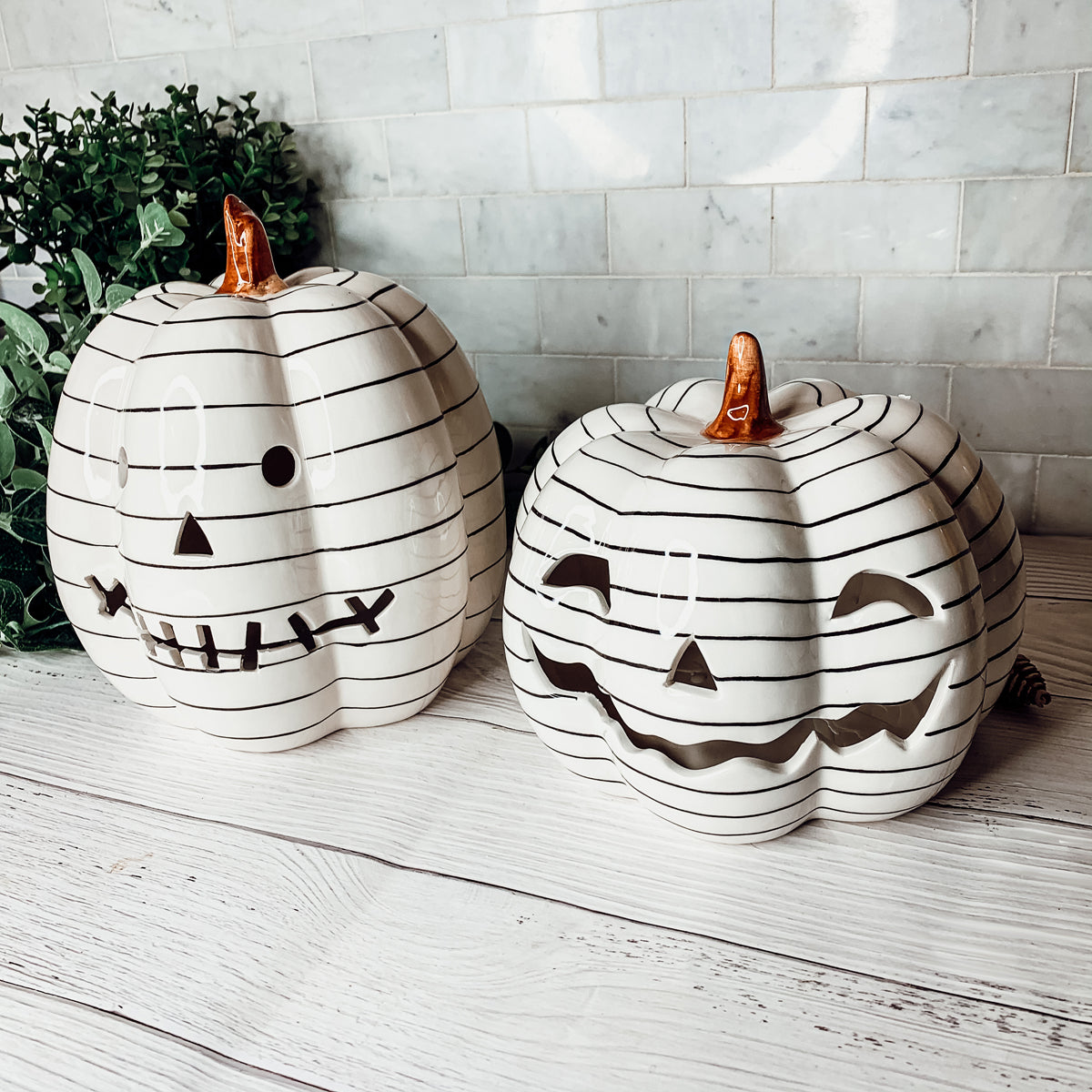 A hand-painted black and white LED pumpkin with a contemporary striped design, perfect for Halloween decor.