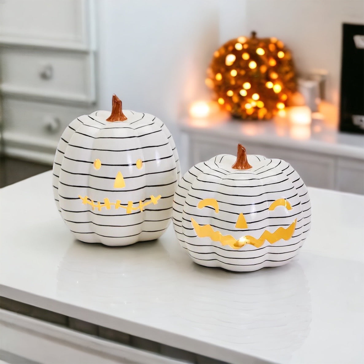 A hand-painted black and white LED pumpkin with a contemporary striped design, perfect for Halloween decor.