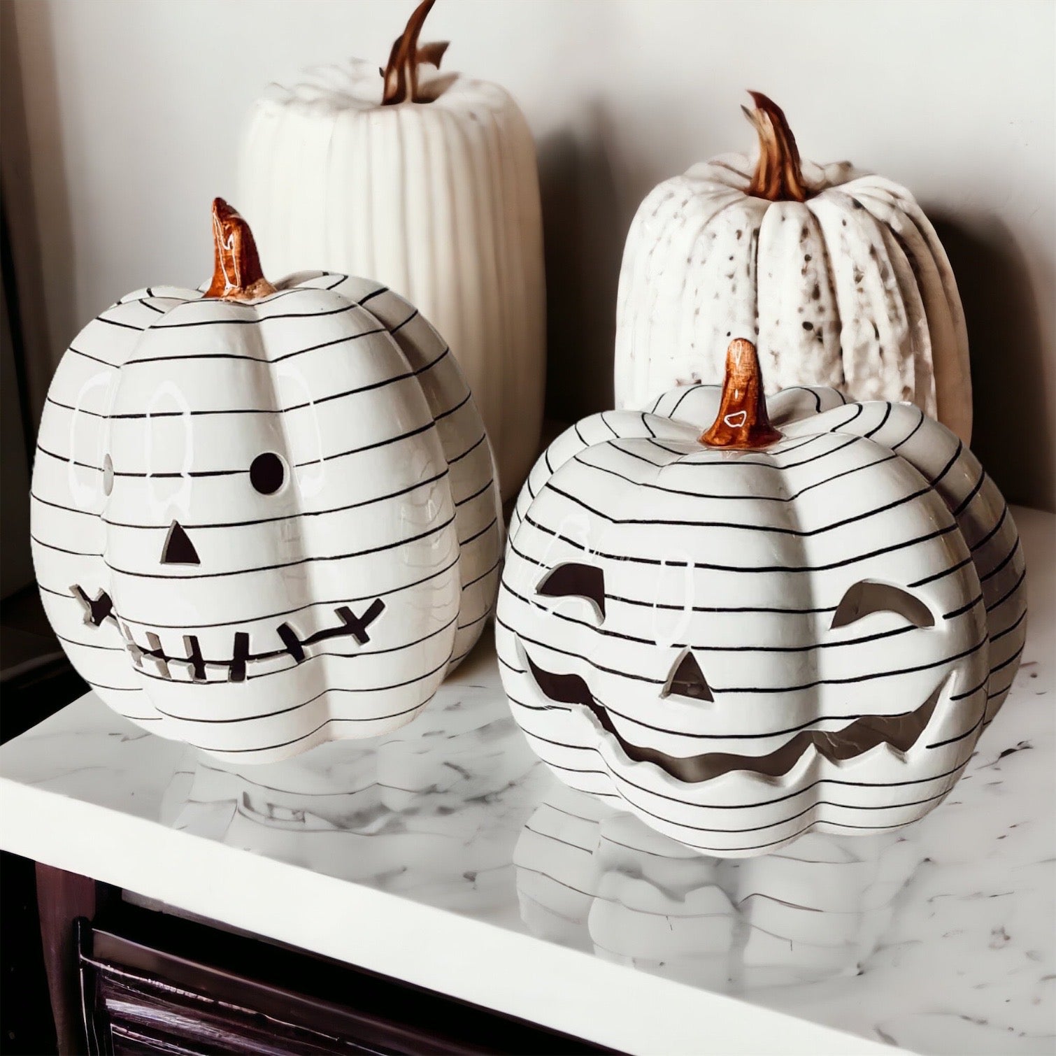 A hand-painted black and white LED pumpkin with a contemporary striped design, perfect for Halloween decor.