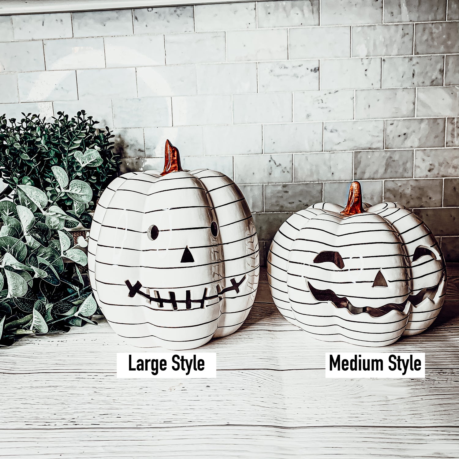 A hand-painted black and white LED pumpkin with a contemporary striped design, perfect for Halloween decor.