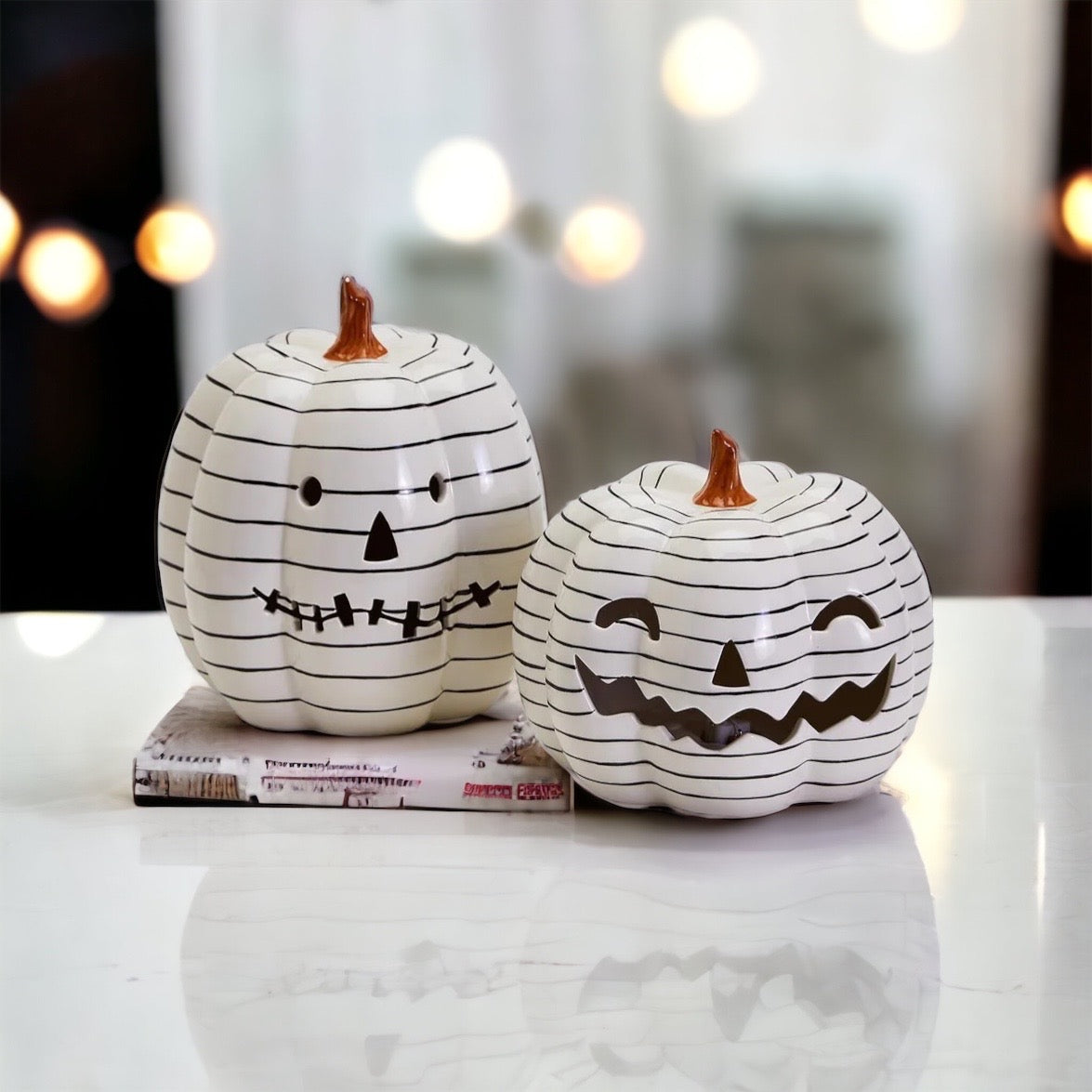 A hand-painted black and white LED pumpkin with a contemporary striped design, perfect for Halloween decor.