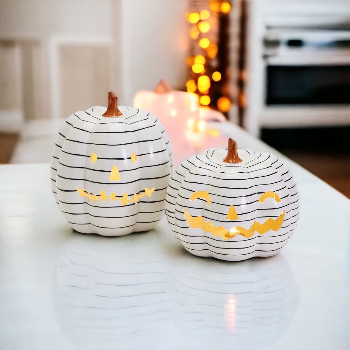 A hand-painted black and white LED pumpkin with a contemporary striped design, perfect for Halloween decor.