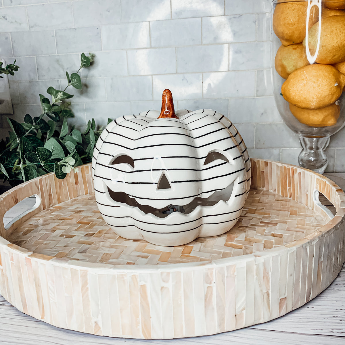 A hand-painted black and white LED pumpkin with a contemporary striped design, perfect for Halloween decor.