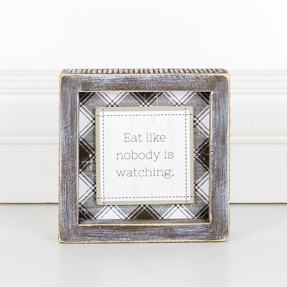 A decorative sign that reads 'Eat Like Nobody is Watching', measuring 5 inches by 5 inches, designed to hang or stand, perfect for kitchens or dining areas.