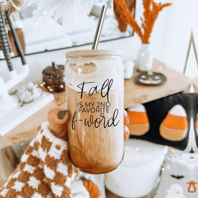 A stylish Fall F-Word Cup made of high borosilicate glass with a bamboo lid, featuring a black graphic text that reads 'FALL IS MY 2ND FAVORITE F-WORD', accompanied by stainless steel straws.