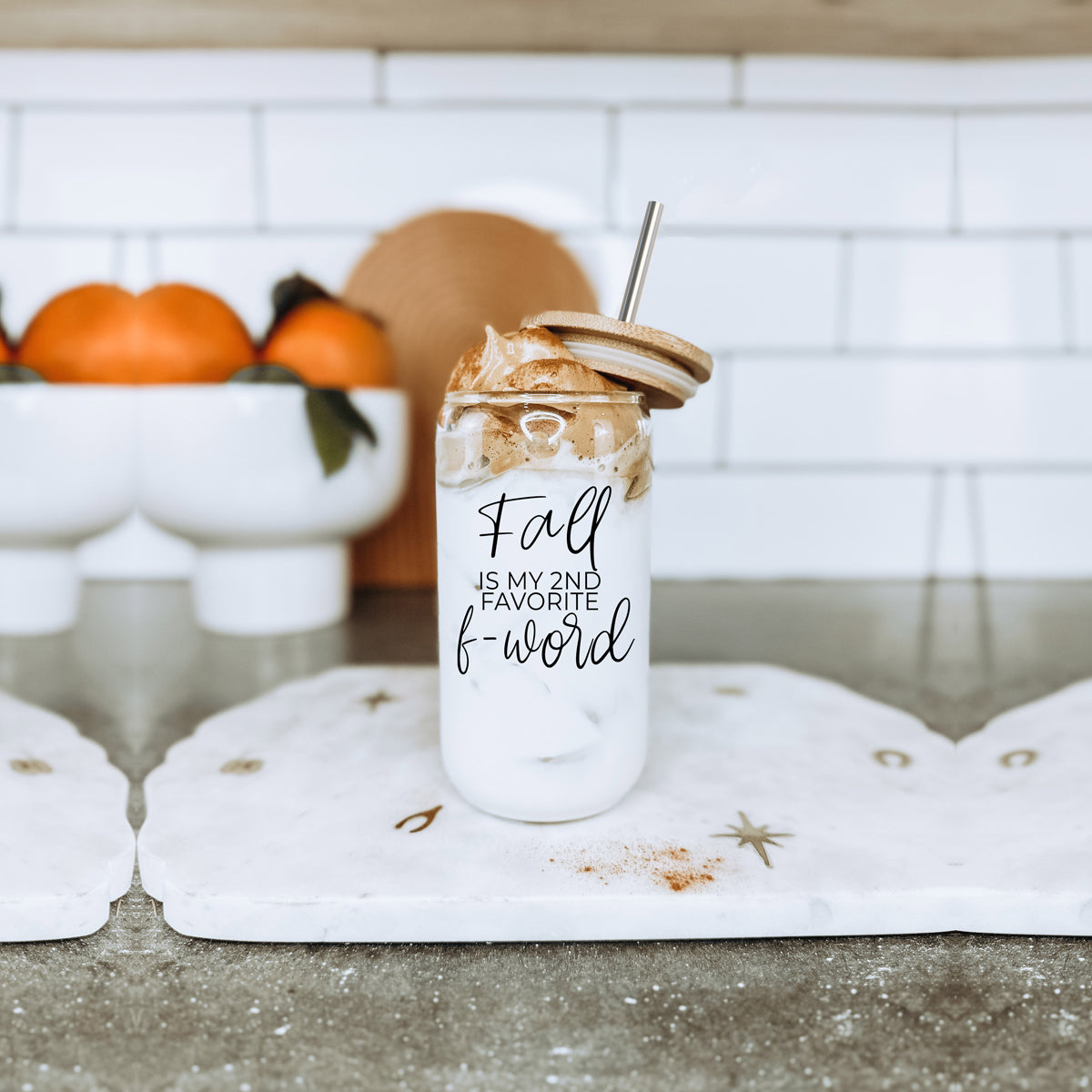 A stylish Fall F-Word Cup made of high borosilicate glass with a bamboo lid, featuring a black graphic text that reads 'FALL IS MY 2ND FAVORITE F-WORD', accompanied by stainless steel straws.