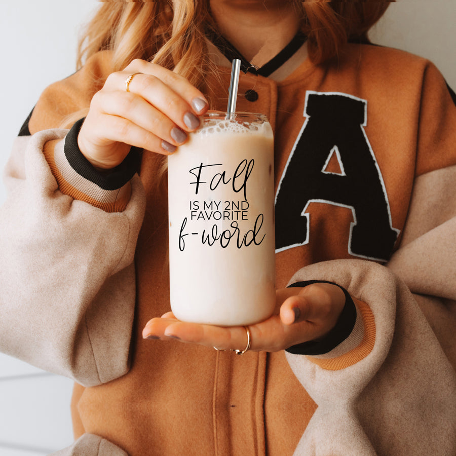 A stylish Fall F-Word Cup made of high borosilicate glass with a bamboo lid, featuring a black graphic text that reads 'FALL IS MY 2ND FAVORITE F-WORD', accompanied by stainless steel straws.