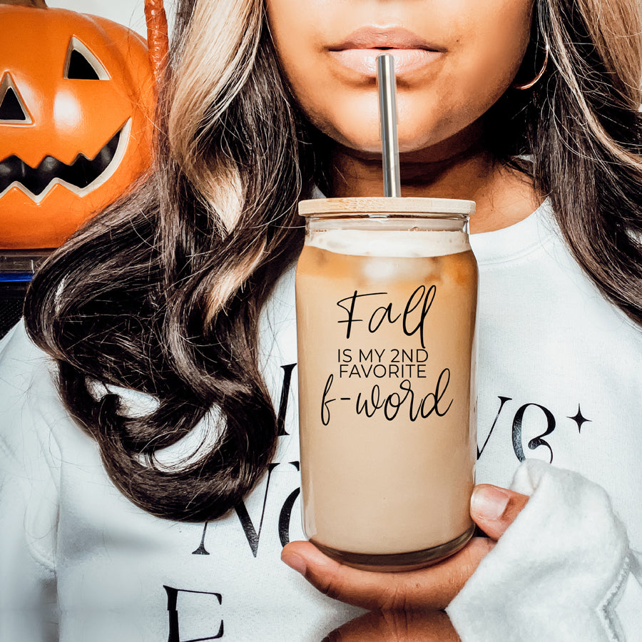 A stylish Fall F-Word Cup made of high borosilicate glass with a bamboo lid, featuring a black graphic text that reads 'FALL IS MY 2ND FAVORITE F-WORD', accompanied by stainless steel straws.