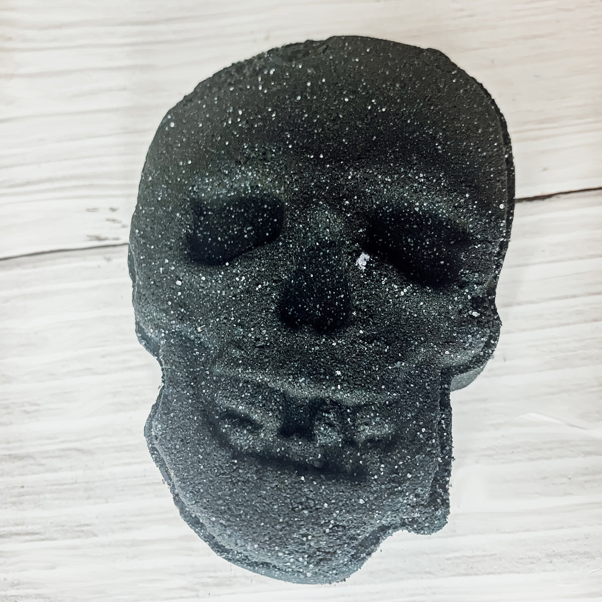 A large 5oz Halloween Skull Bath Bomb shaped like a skeleton skull, featuring a vibrant design and infused with eucalyptus and spearmint scents.