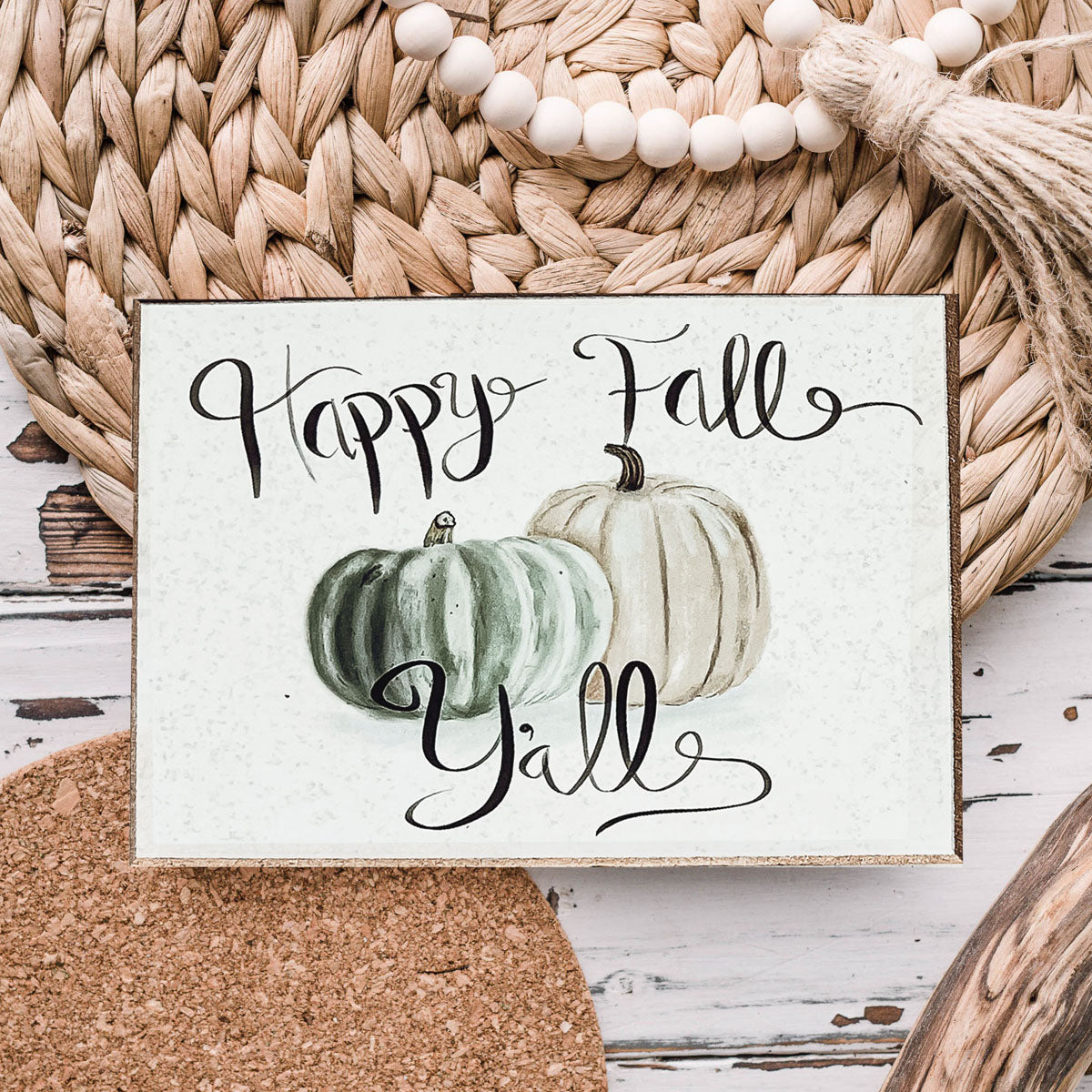 A charming wooden sign that reads 'Happy Fall Y'all' in pastel colors on an off-white background, perfect for autumn decor.