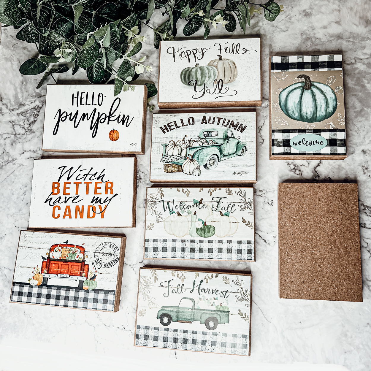 A charming wooden sign that reads 'Happy Fall Y'all' in pastel colors on an off-white background, perfect for autumn decor.