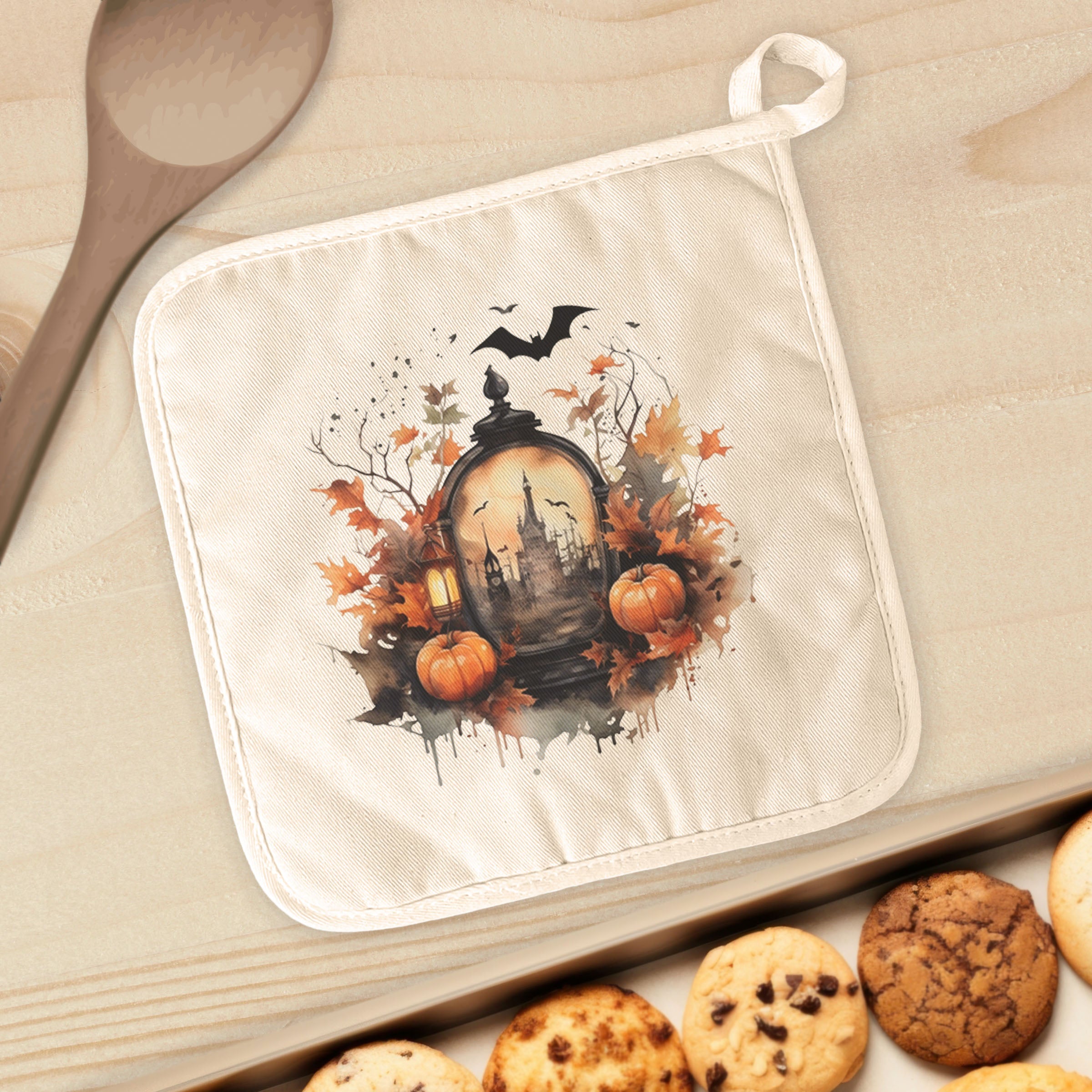 A vibrant cotton pot holder featuring a haunted house scene, perfect for protecting surfaces from hot cookware.