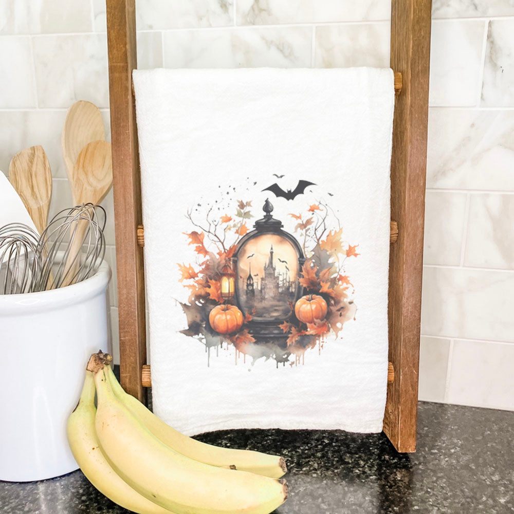 A cotton tea towel featuring a haunted house scene, showcasing vibrant colors and intricate details, perfect for Halloween decor.