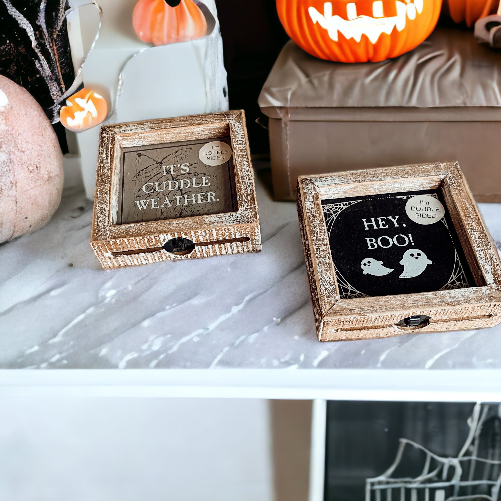 A double-sided wooden sign featuring 'Hey Boo' on one side and 'It's Cuddle Weather' on the other, measuring 5x5 inches.