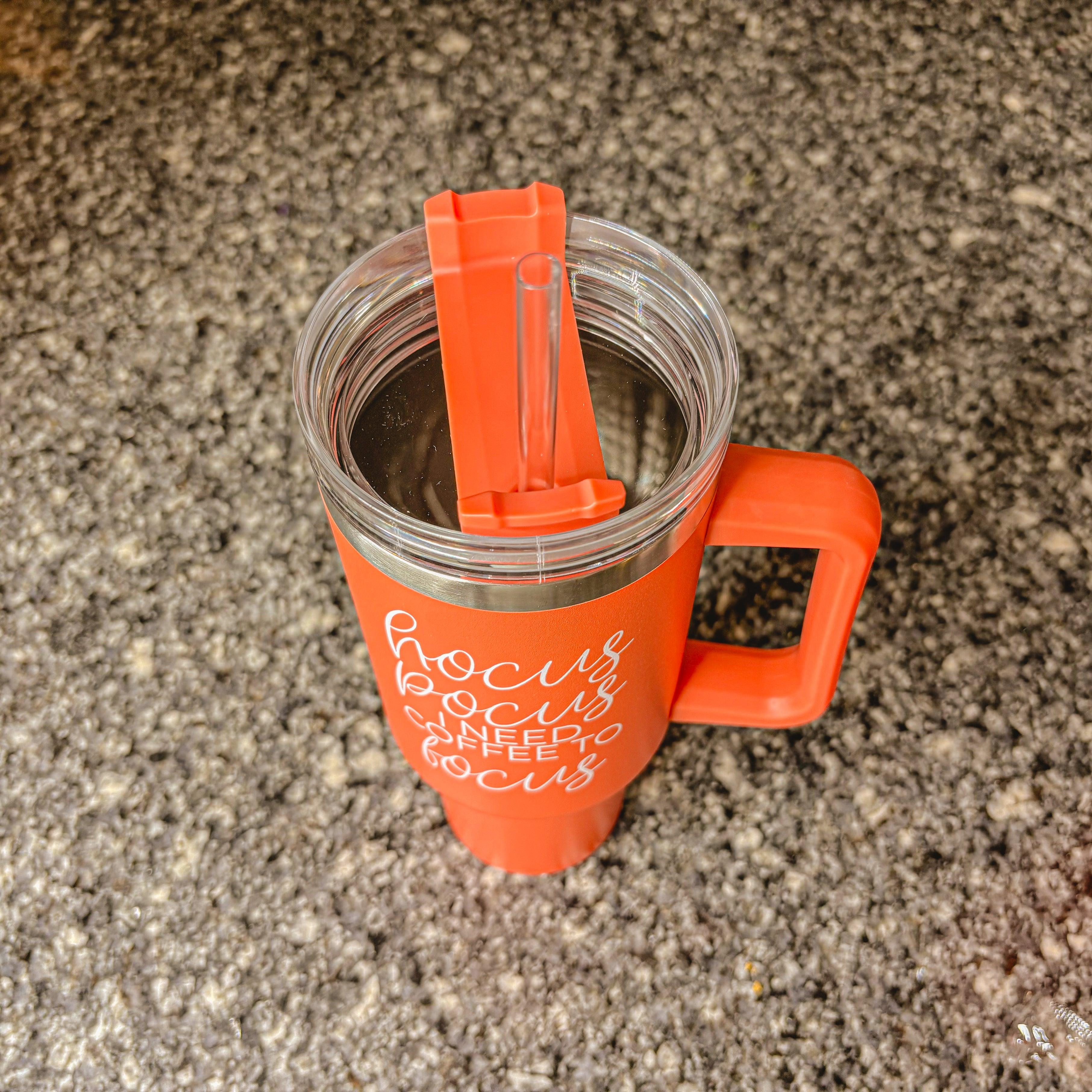 Hocus Pocus 40oz Tumbler in orange with lid and straw, featuring autumn leaves design.