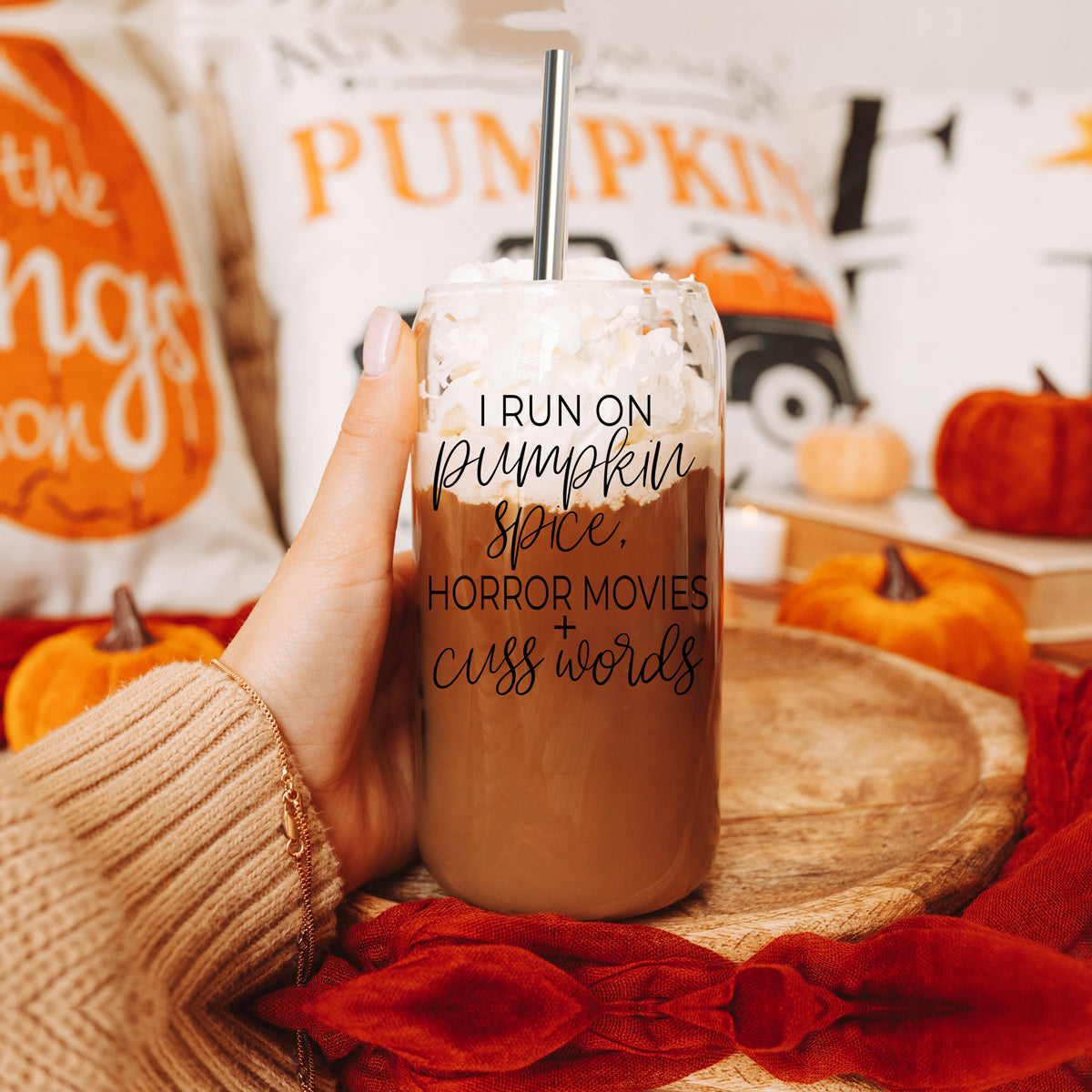 A stylish glass cup with a bamboo lid, featuring the phrase 'I RUN ON PUMPKIN SPICE, HORROR MOVIES + CUSS WORDS' in black graphic design.