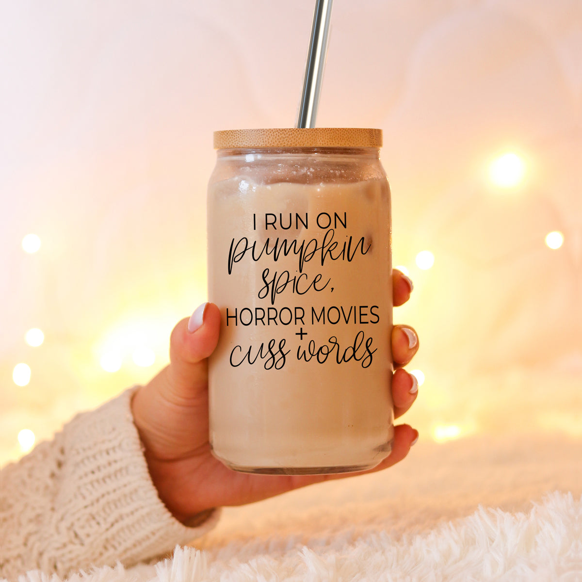 A stylish glass cup with a bamboo lid, featuring the phrase 'I RUN ON PUMPKIN SPICE, HORROR MOVIES + CUSS WORDS' in black graphic design.