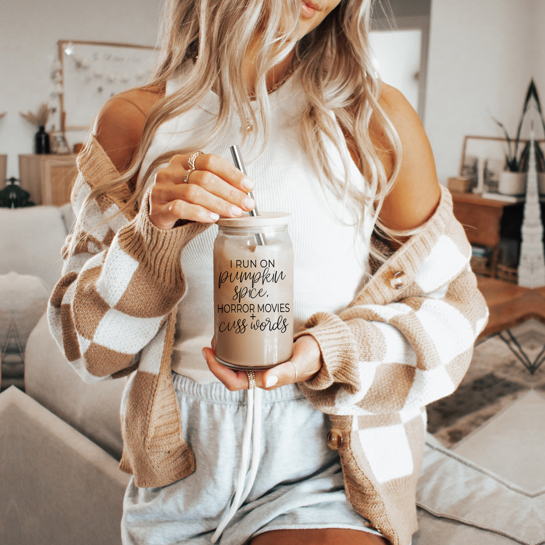 A stylish glass cup with a bamboo lid, featuring the phrase 'I RUN ON PUMPKIN SPICE, HORROR MOVIES + CUSS WORDS' in black graphic design.