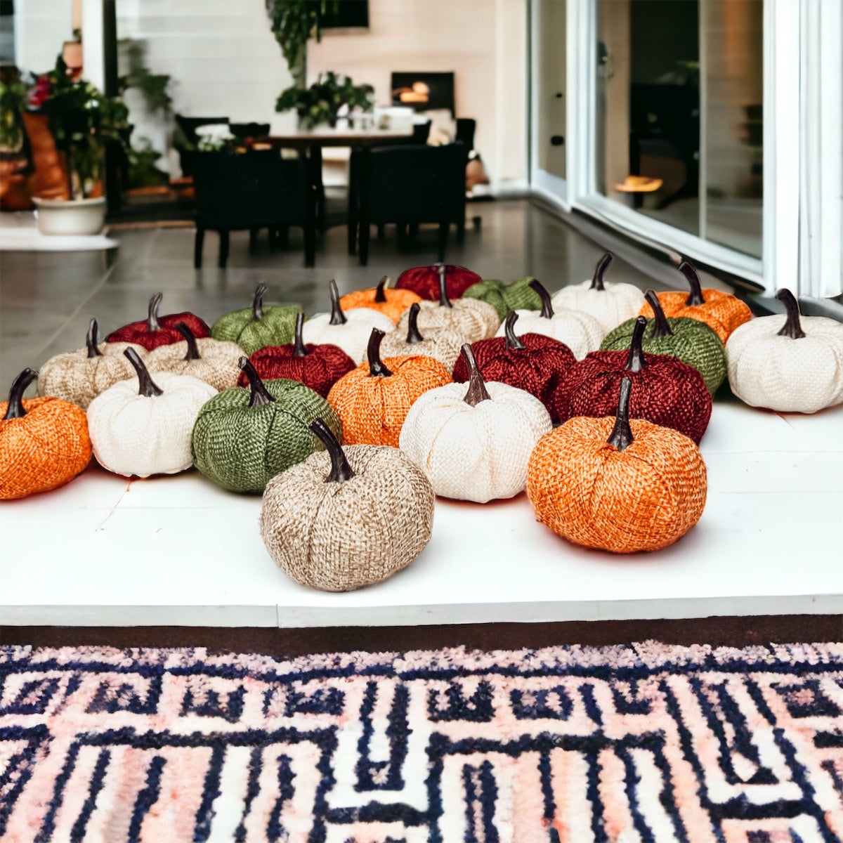 A collection of colorful jute mini pumpkins in various shades including burgundy, beige, green, ivory, and orange, perfect for fall decor.