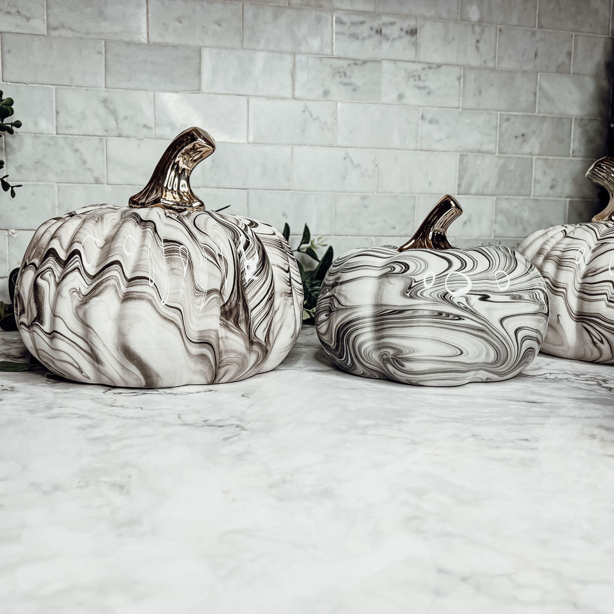 Martha Black Pumpkin featuring a unique marbled design and a luxurious gold-toned metallic stem, perfect for Halloween and year-round decor.