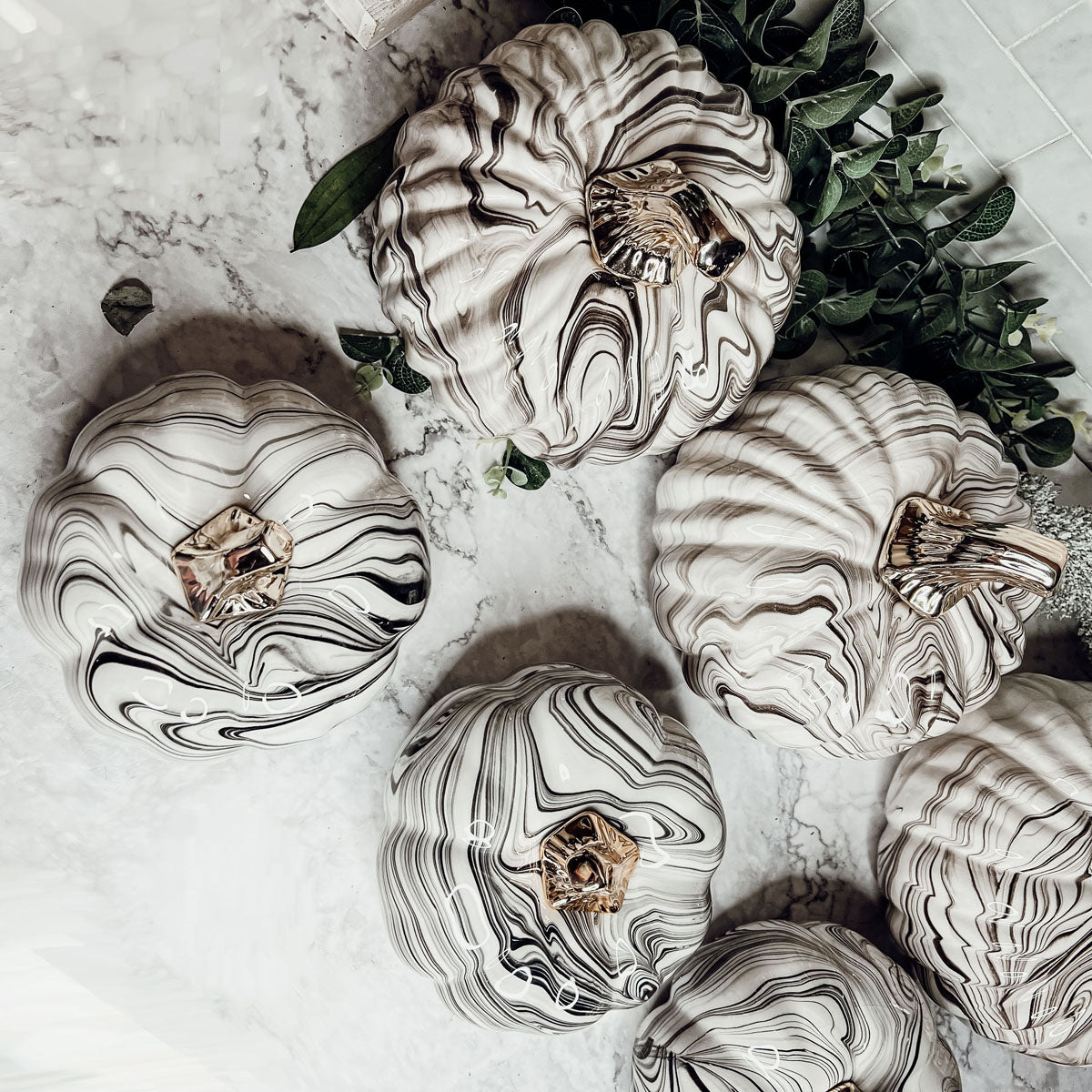 Martha Black Pumpkin featuring a unique marbled design and a luxurious gold-toned metallic stem, perfect for Halloween and year-round decor.