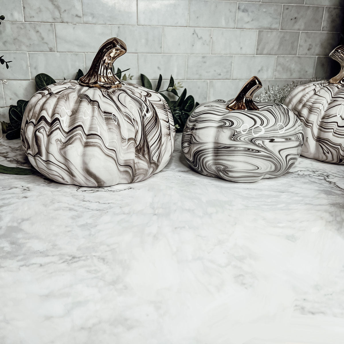 Martha Black Pumpkin featuring a unique marbled design and a luxurious gold-toned metallic stem, perfect for Halloween and year-round decor.