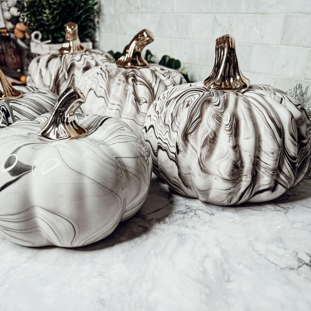 Martha Black Pumpkin featuring a unique marbled design and a luxurious gold-toned metallic stem, perfect for Halloween and year-round decor.