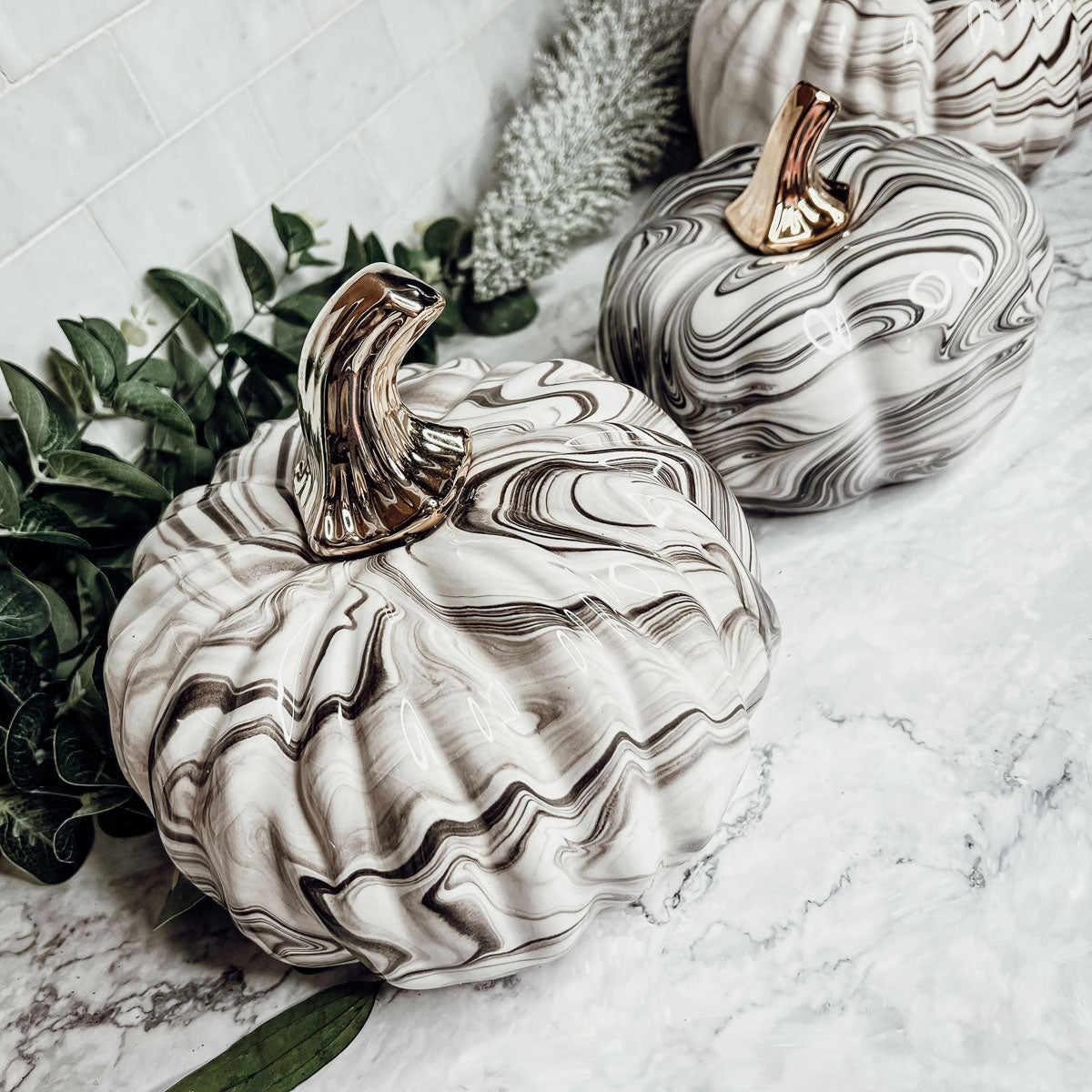 Martha Black Pumpkin featuring a unique marbled design and a luxurious gold-toned metallic stem, perfect for Halloween and year-round decor.