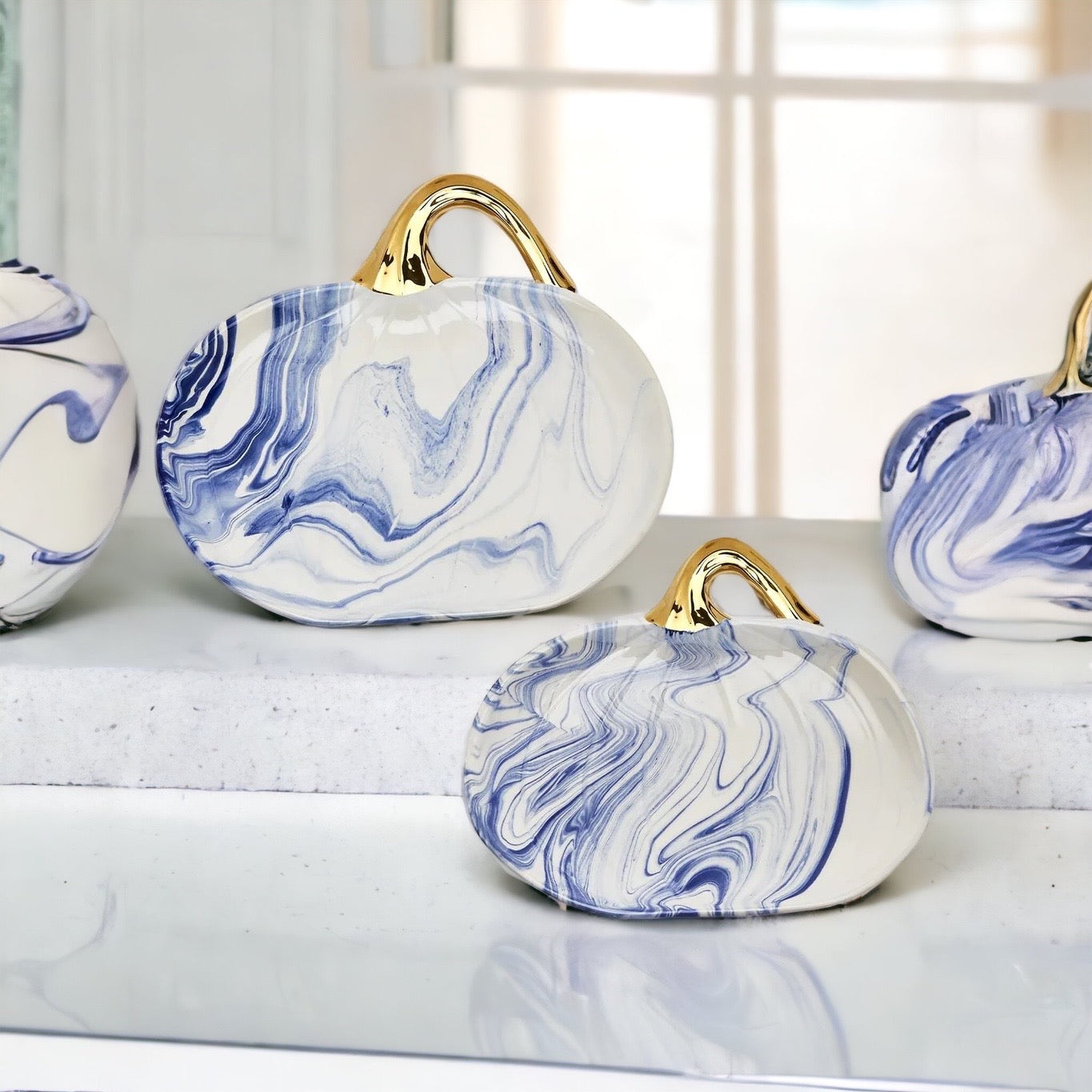 Martha Blue Pumpkin Plate set featuring marbled blue and white design with elegant gold stems, perfect for serving desserts.