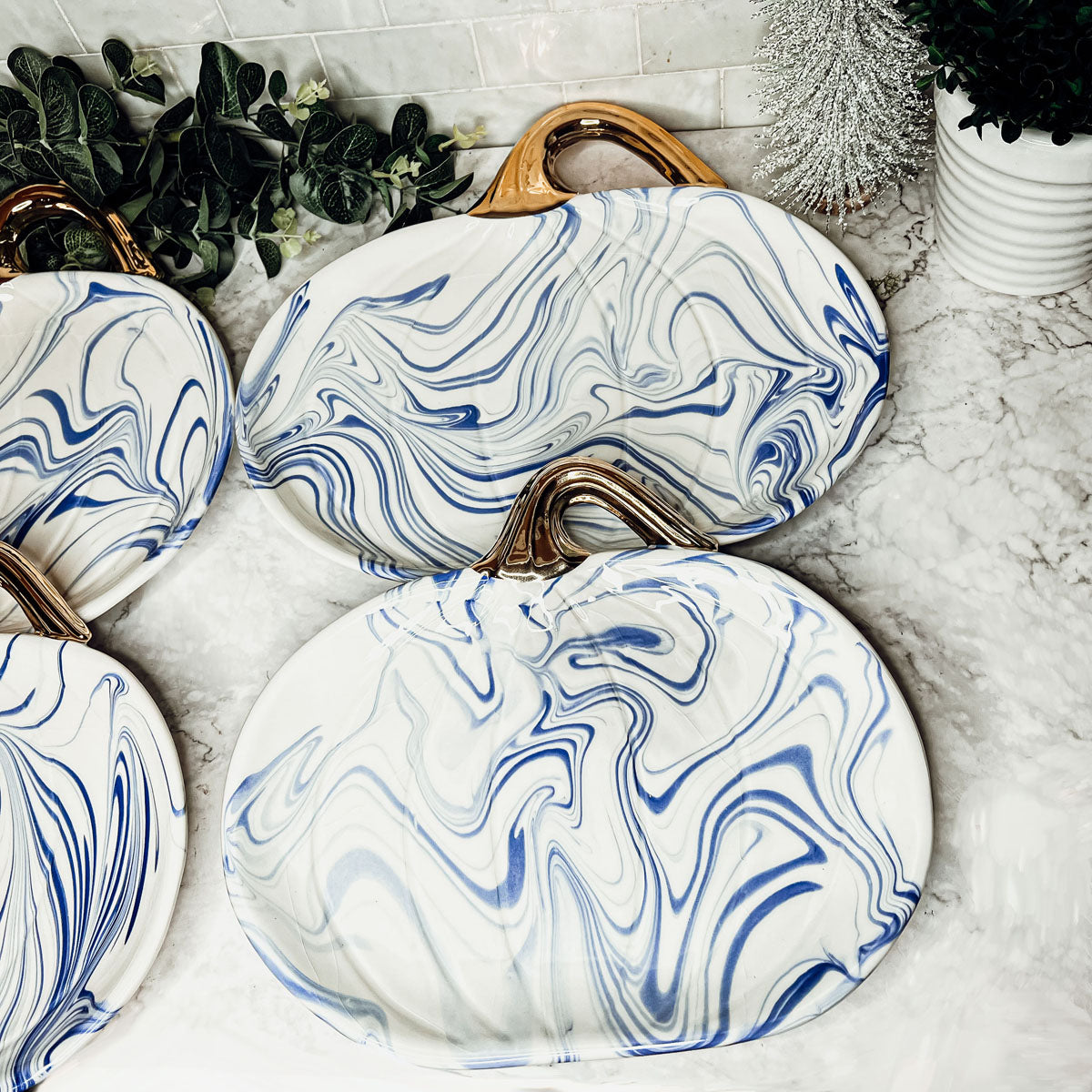 Martha Blue Pumpkin Plate set featuring marbled blue and white design with elegant gold stems, perfect for serving desserts.