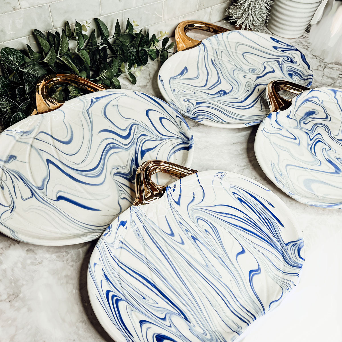 Martha Blue Pumpkin Plate set featuring marbled blue and white design with elegant gold stems, perfect for serving desserts.