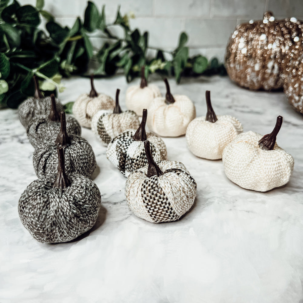 A collection of 12 mini pumpkins in beige, gray, and flannel patterns, perfect for fall and Halloween decor.