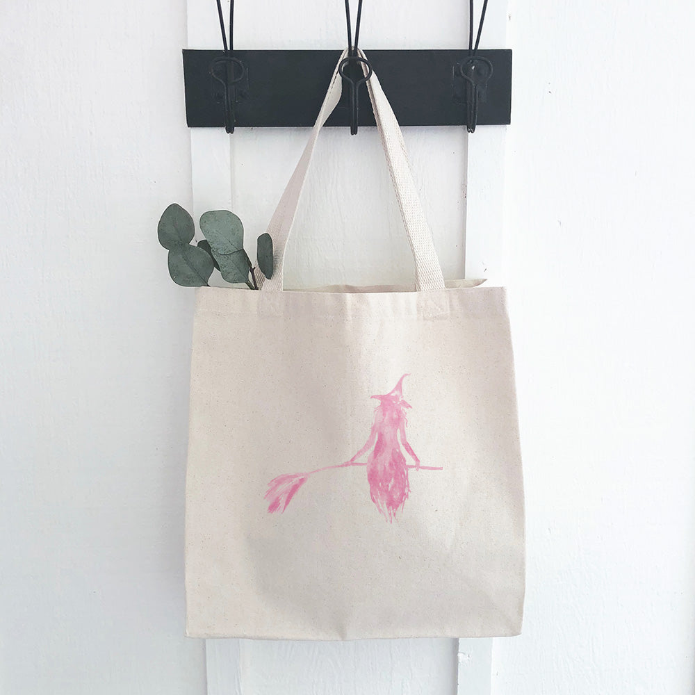 A stylish pink canvas tote bag featuring a witch silhouette design, perfect for shopping and everyday use.