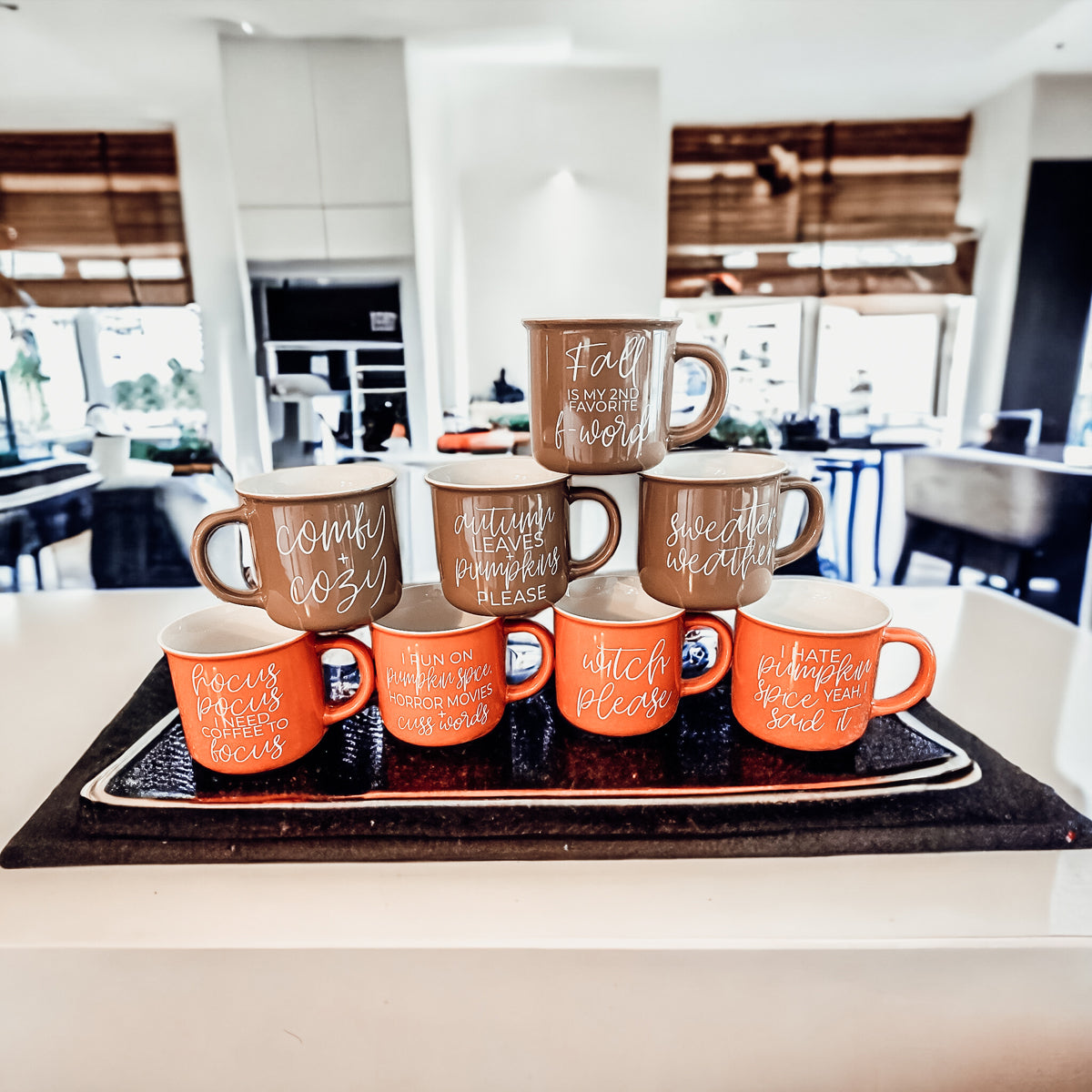 A cozy ceramic campfire style mug in neutral brown with white lettering that says 'Sweater Weather' on both sides.